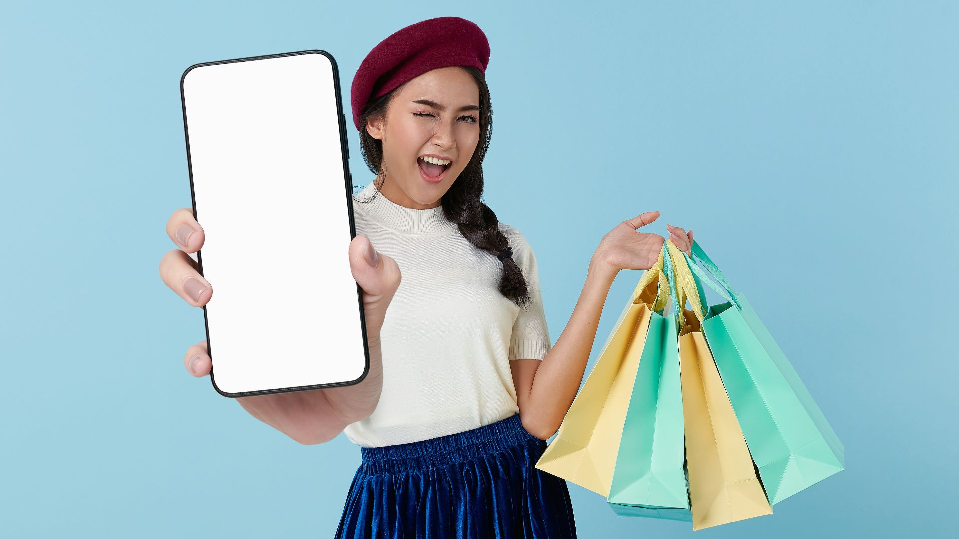 A woman holding a tablet computer and shopping bags