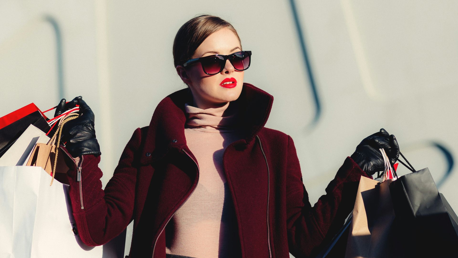 photo of woman holding white and black paper bags