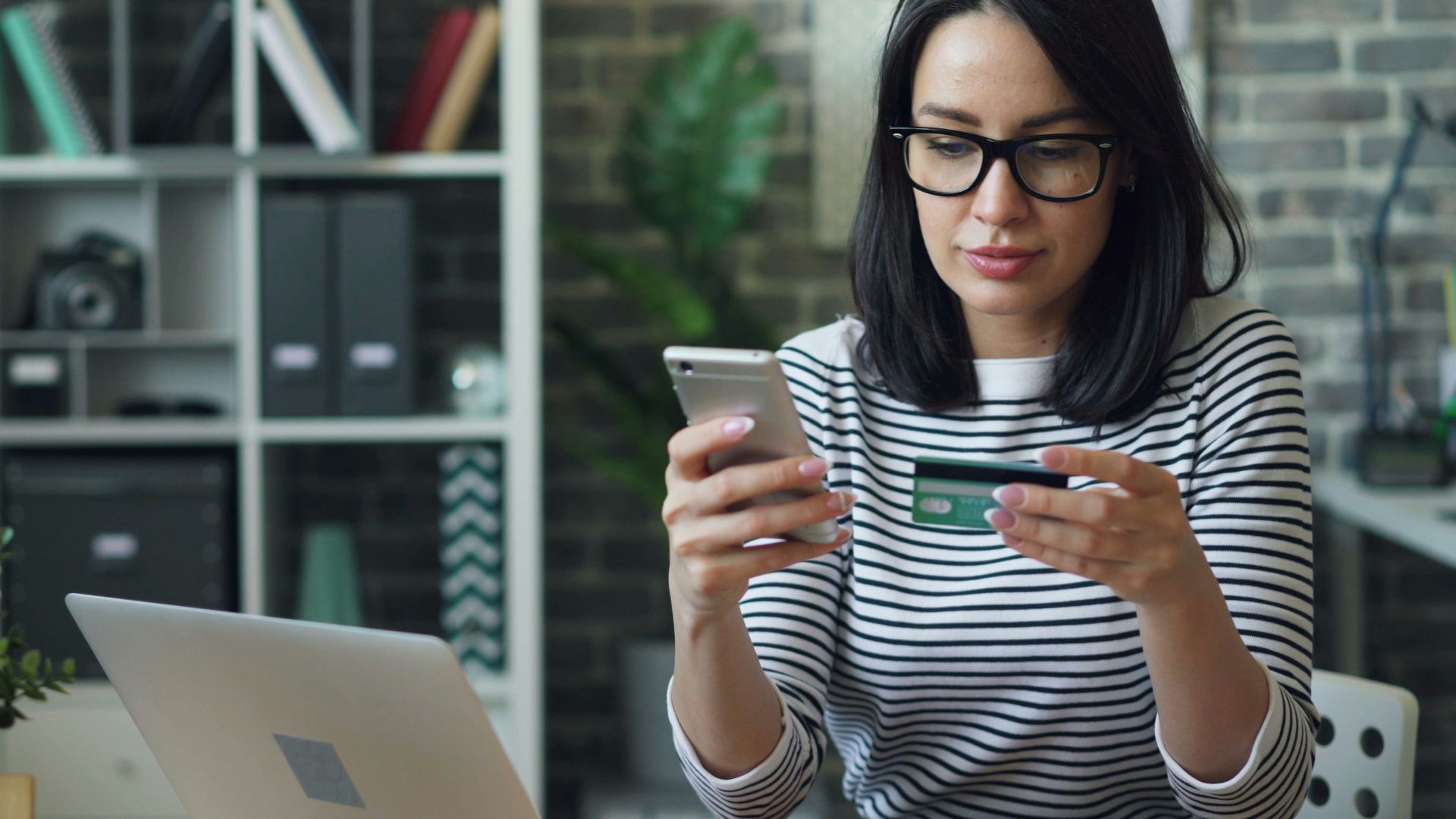 a woman sitting at a table looking at her cell phone