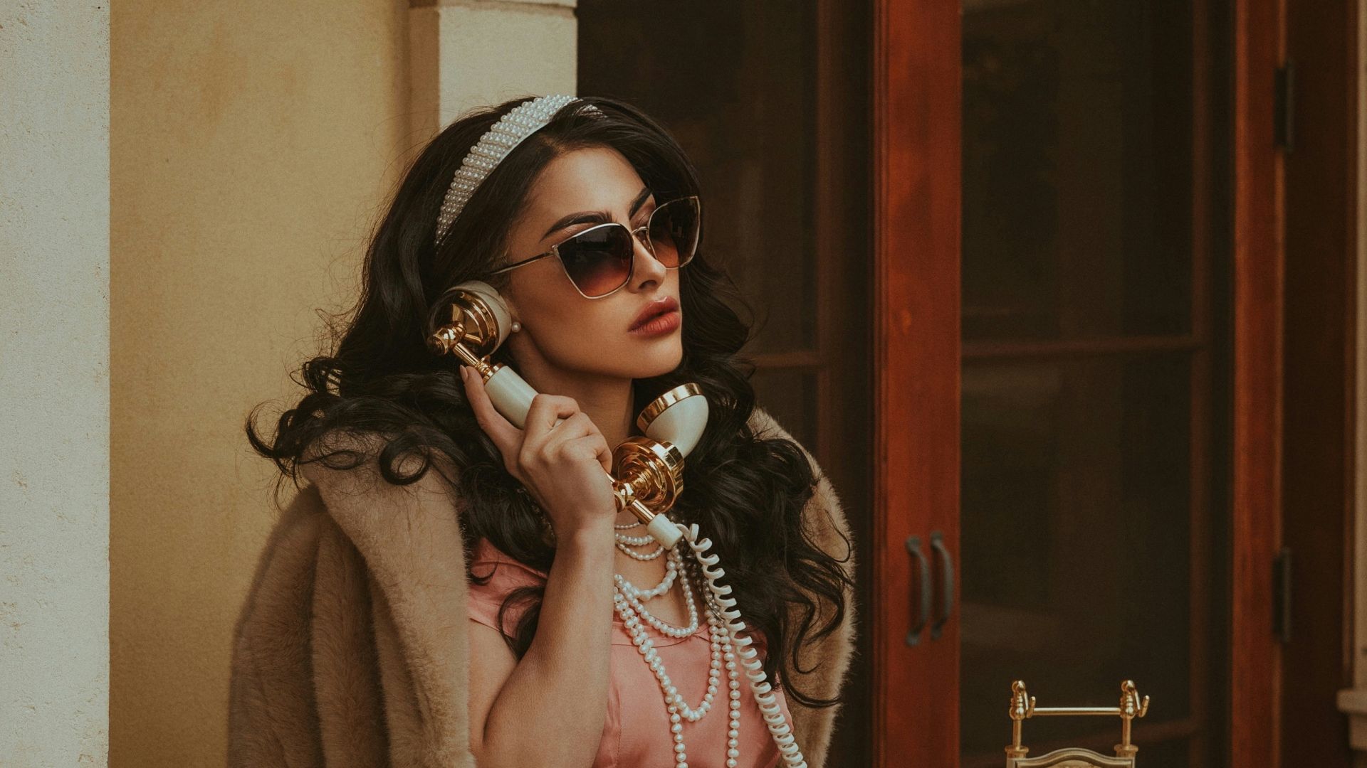 a woman in a pink dress talking on a phone