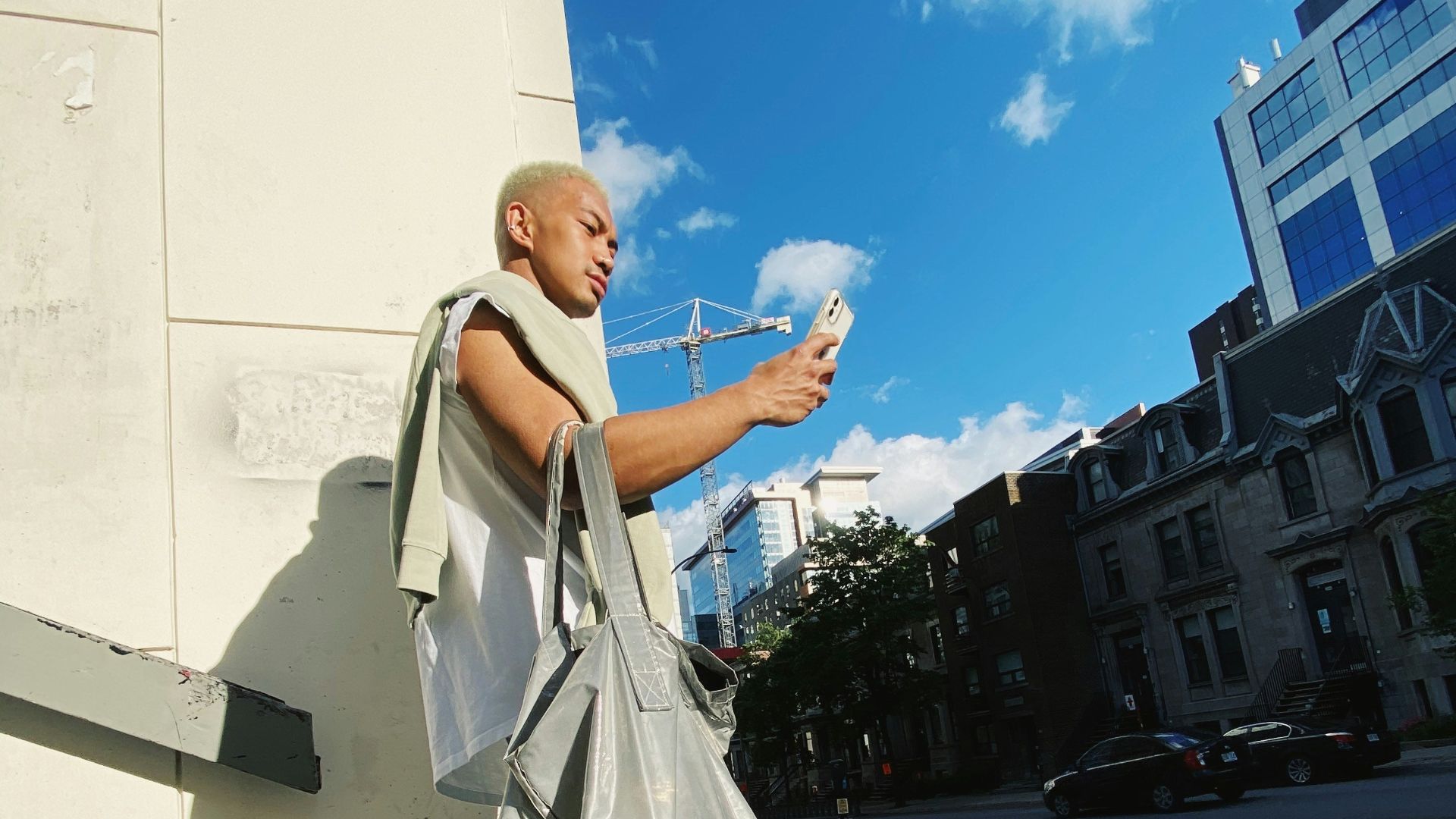 woman in white coat and blue denim jeans standing on gray concrete pavement during daytime