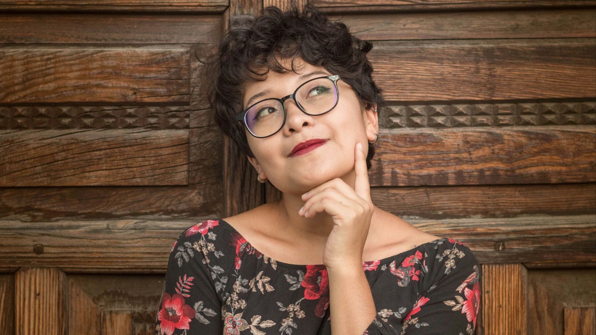 woman leaning against door while holding her cheek