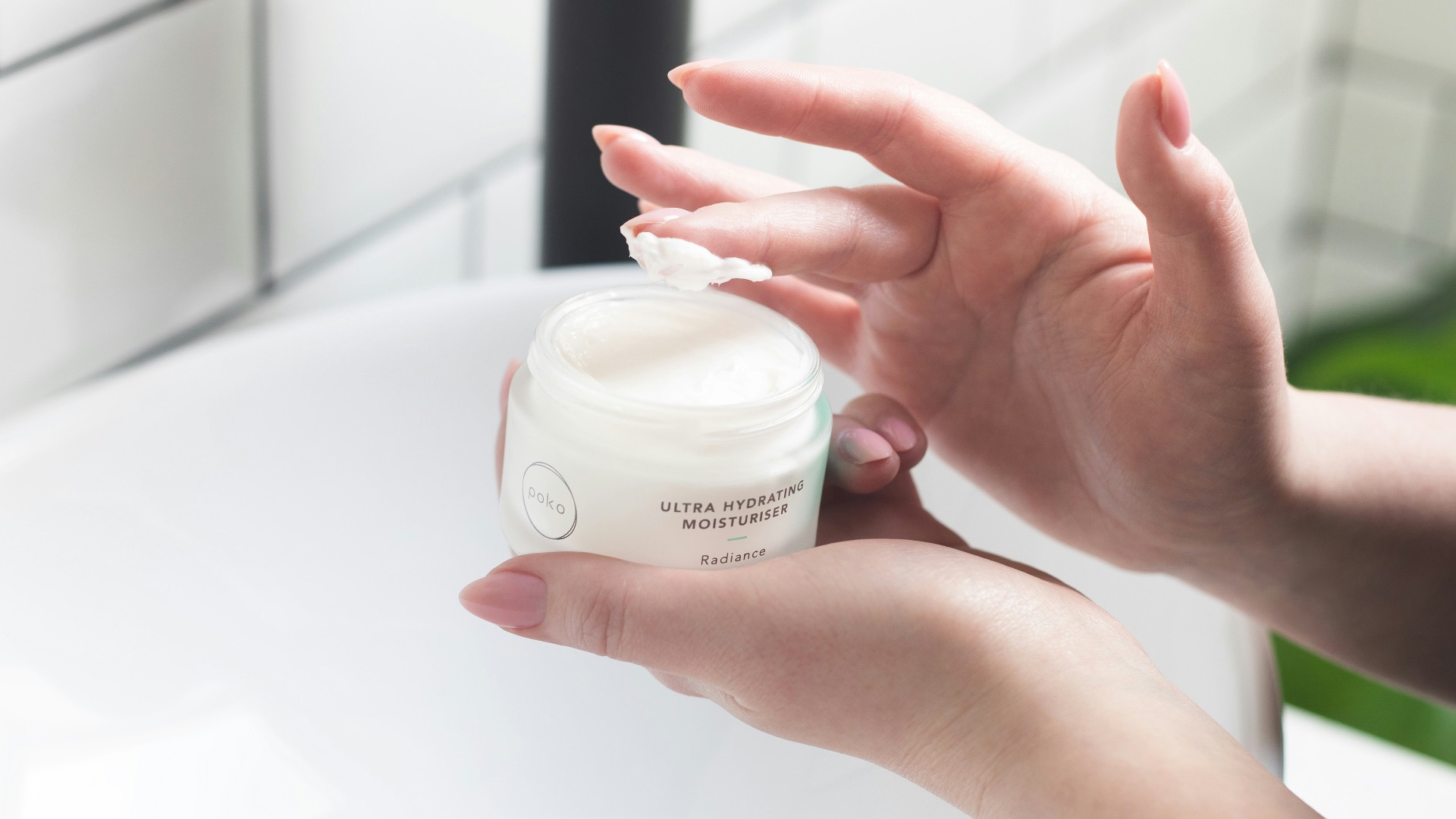 person holding white and black plastic bottle