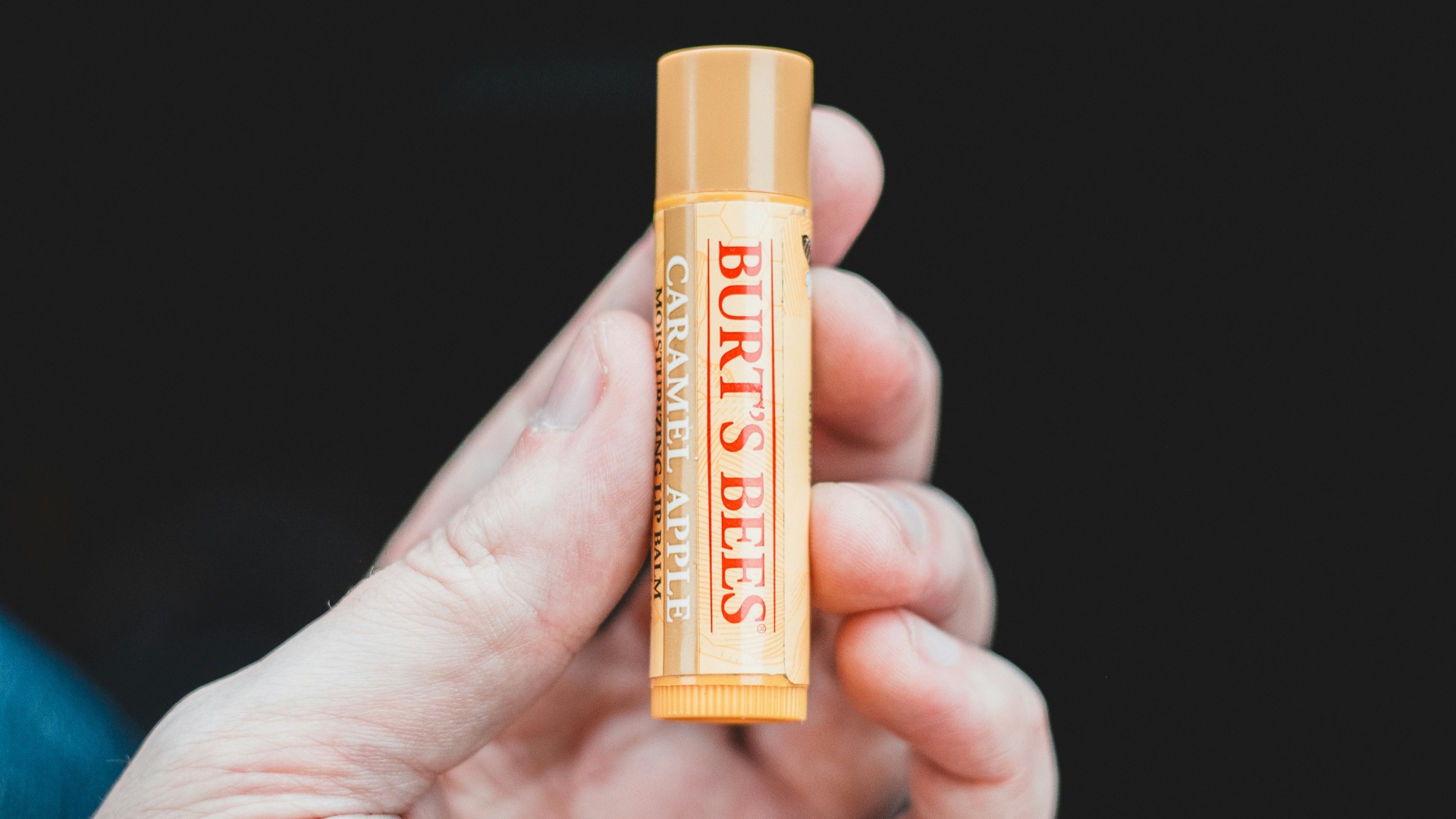 person holding orange and yellow plastic tube