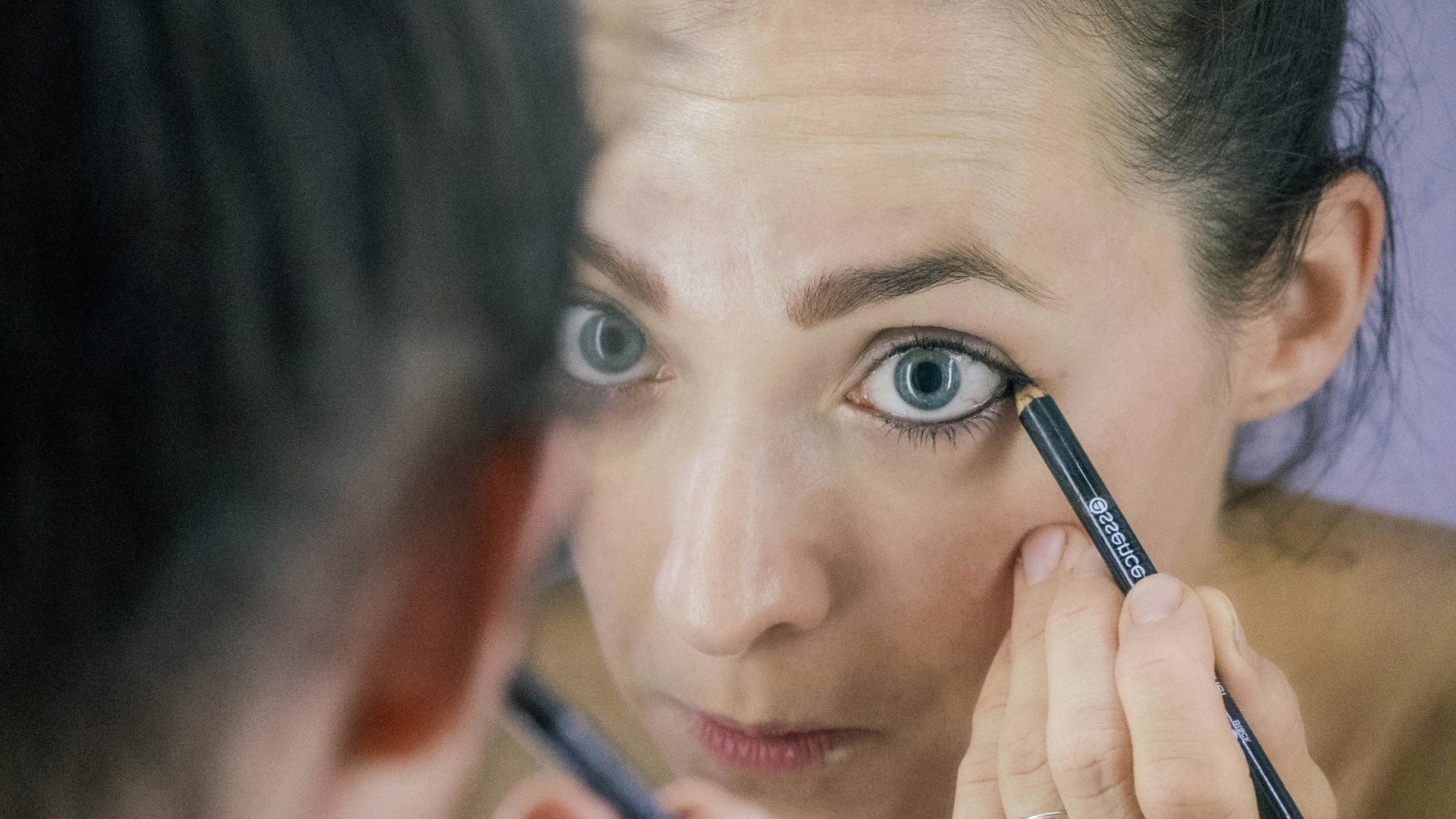 a woman is looking at her reflection in the mirror