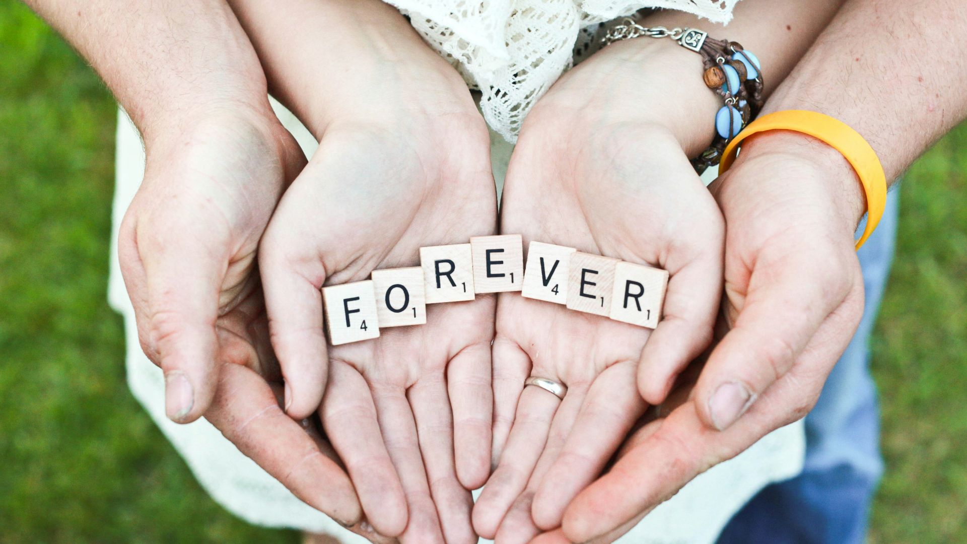 adult and girl holding forever scrabble letters during daytime