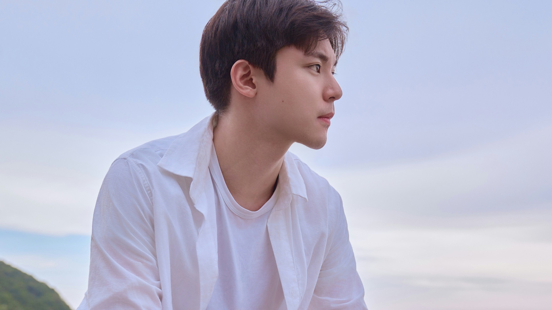 A man sitting on a rock near the ocean