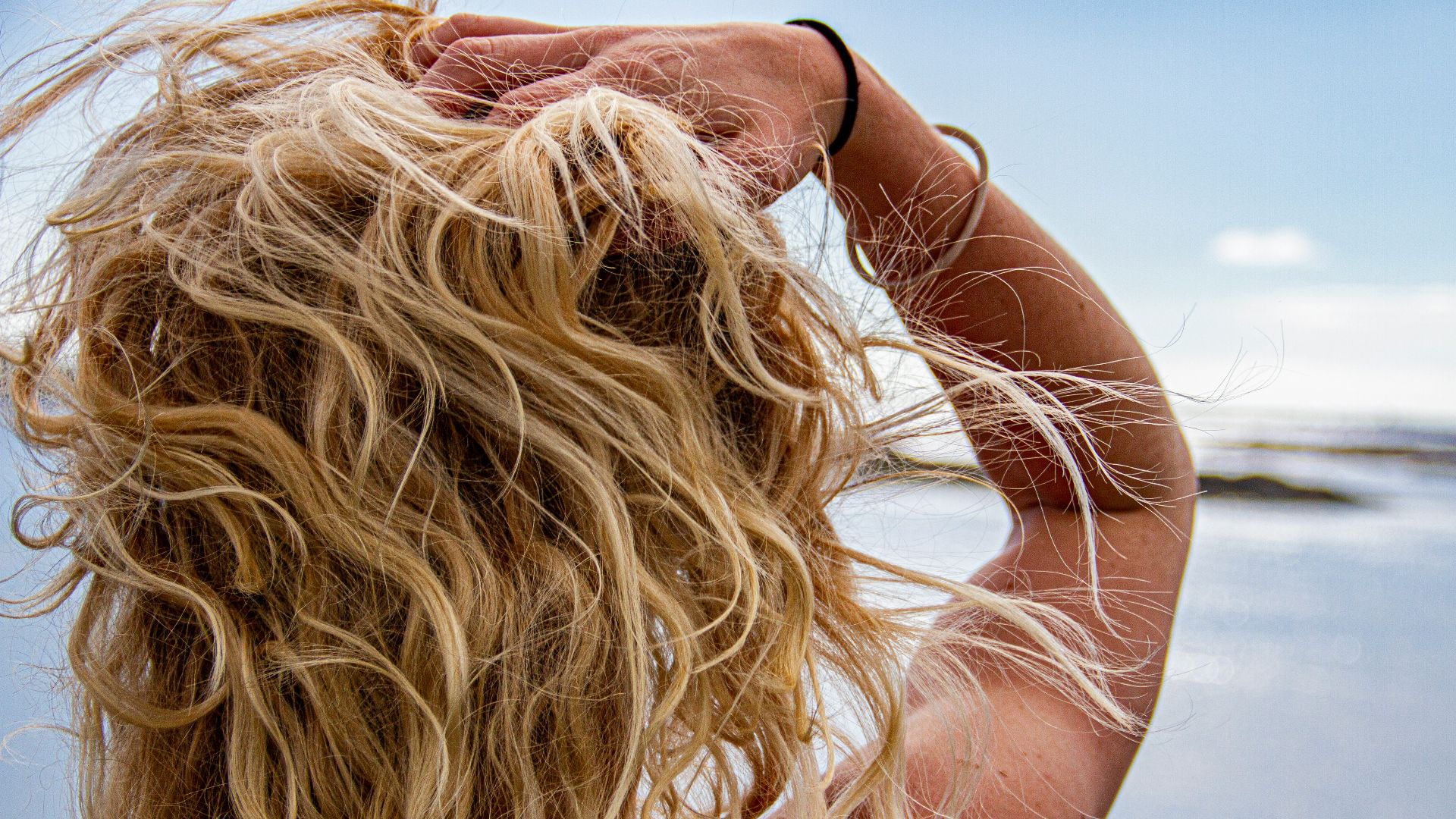 woman in black sunglasses covering her face with her hair