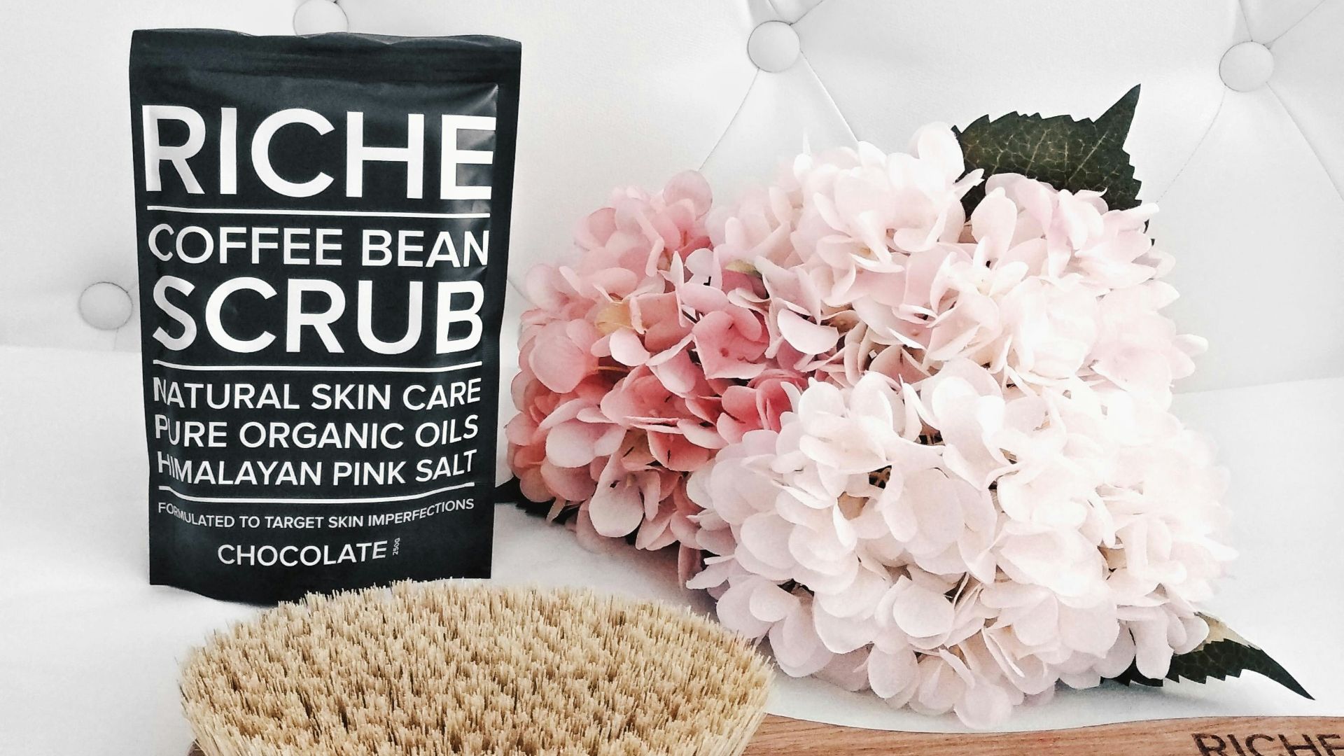 Coffee bean scrub with brush and flowers