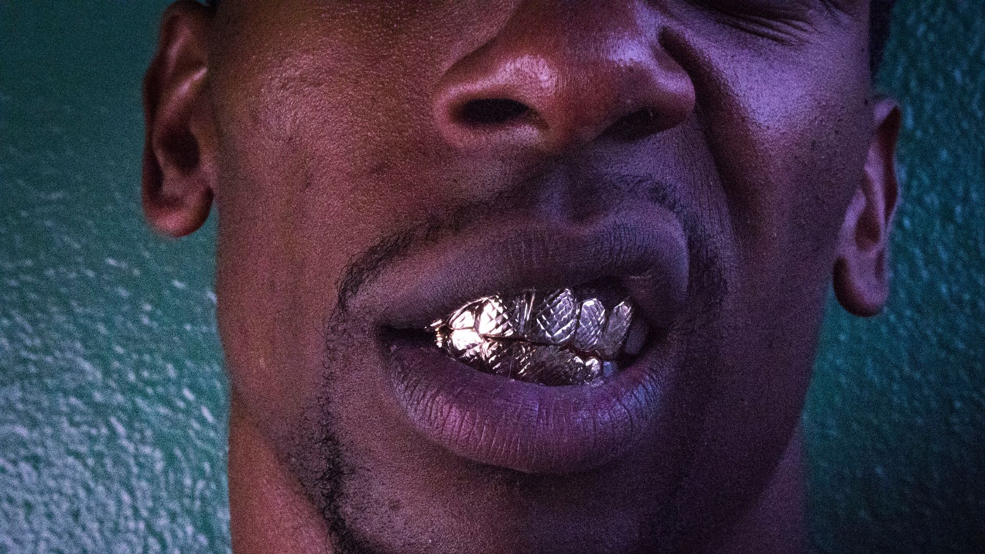 man leaning on green painted wall