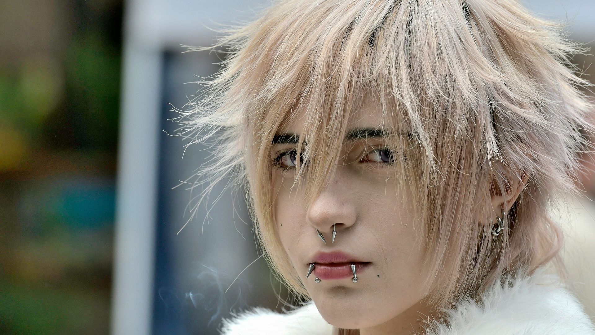 Young woman with blonde hair and piercings.