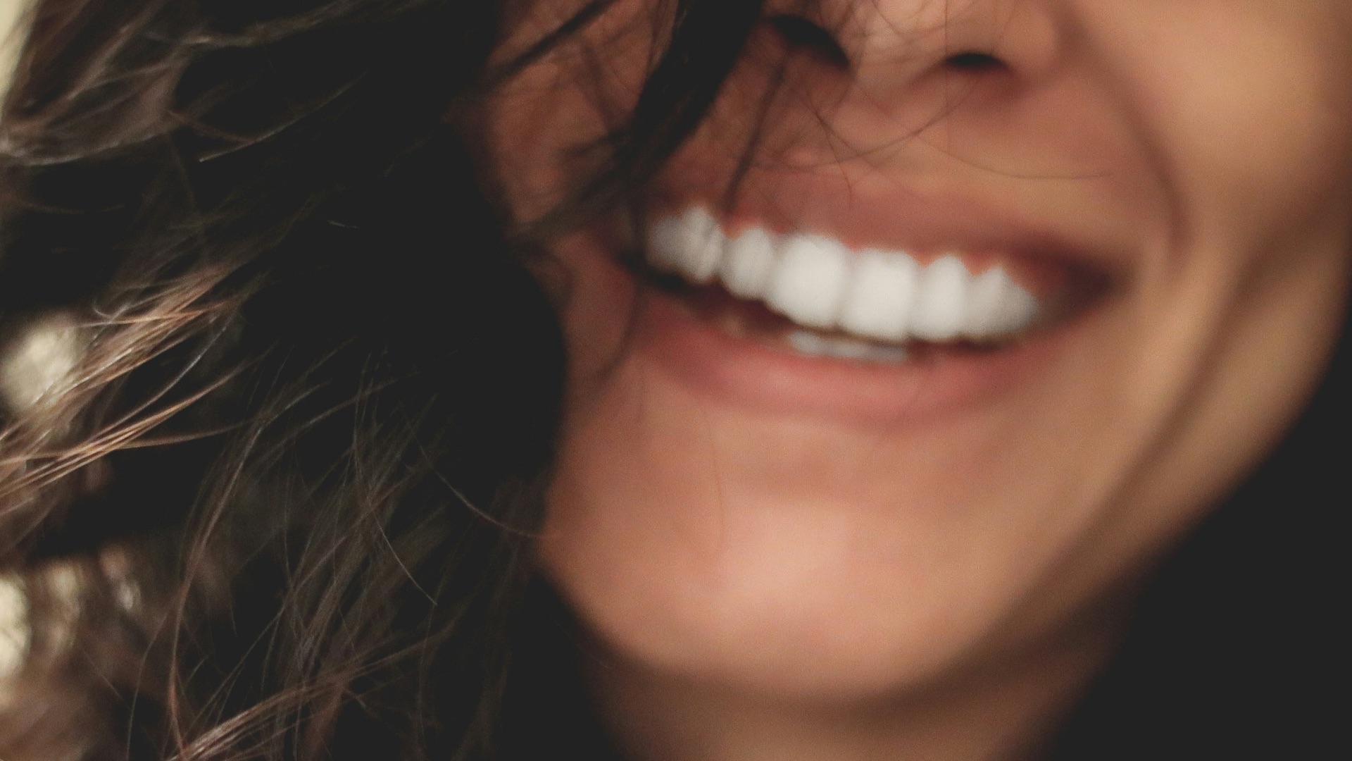 long black haired woman smiling close-up photography