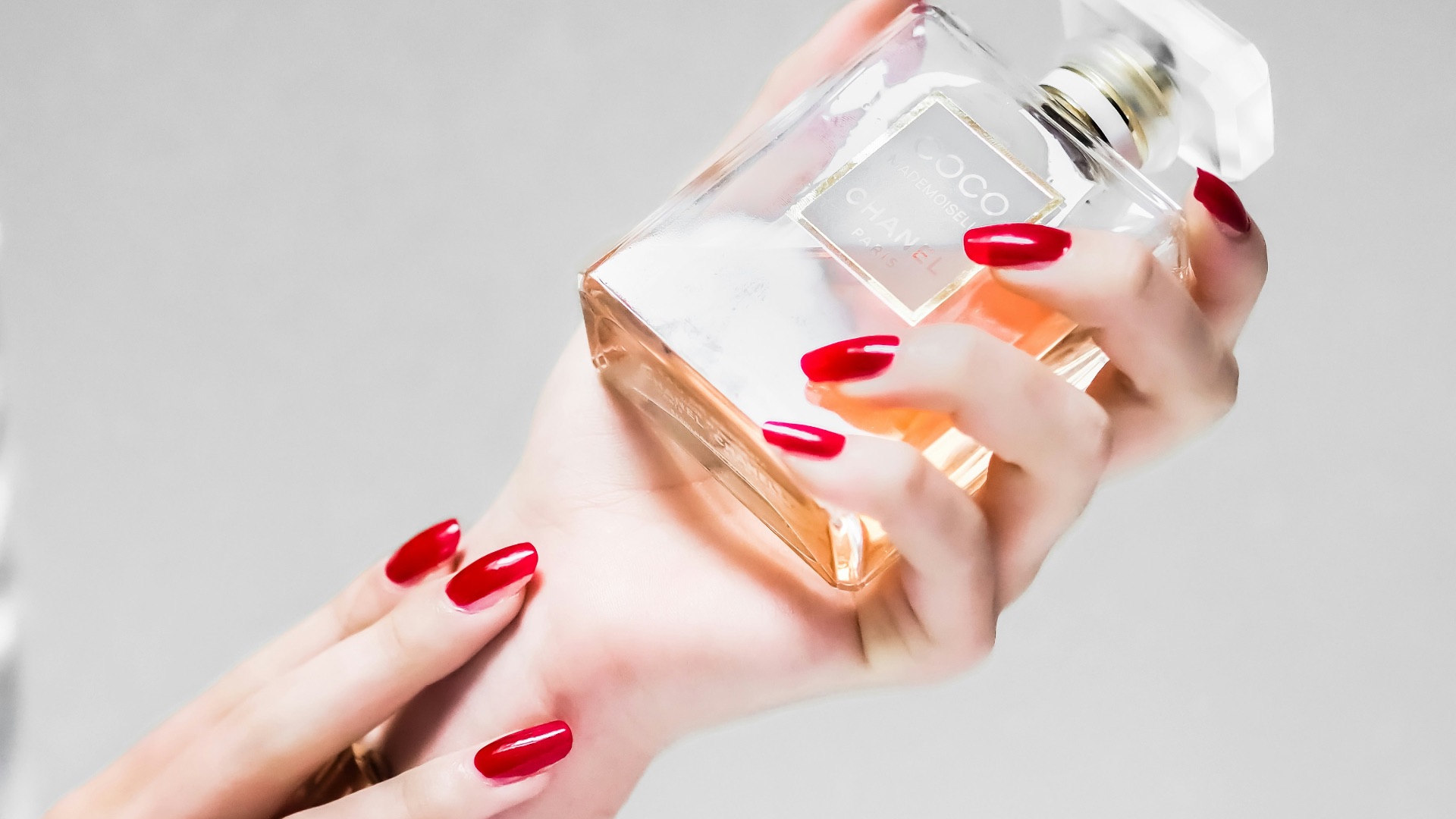 person holding clear glass bottle