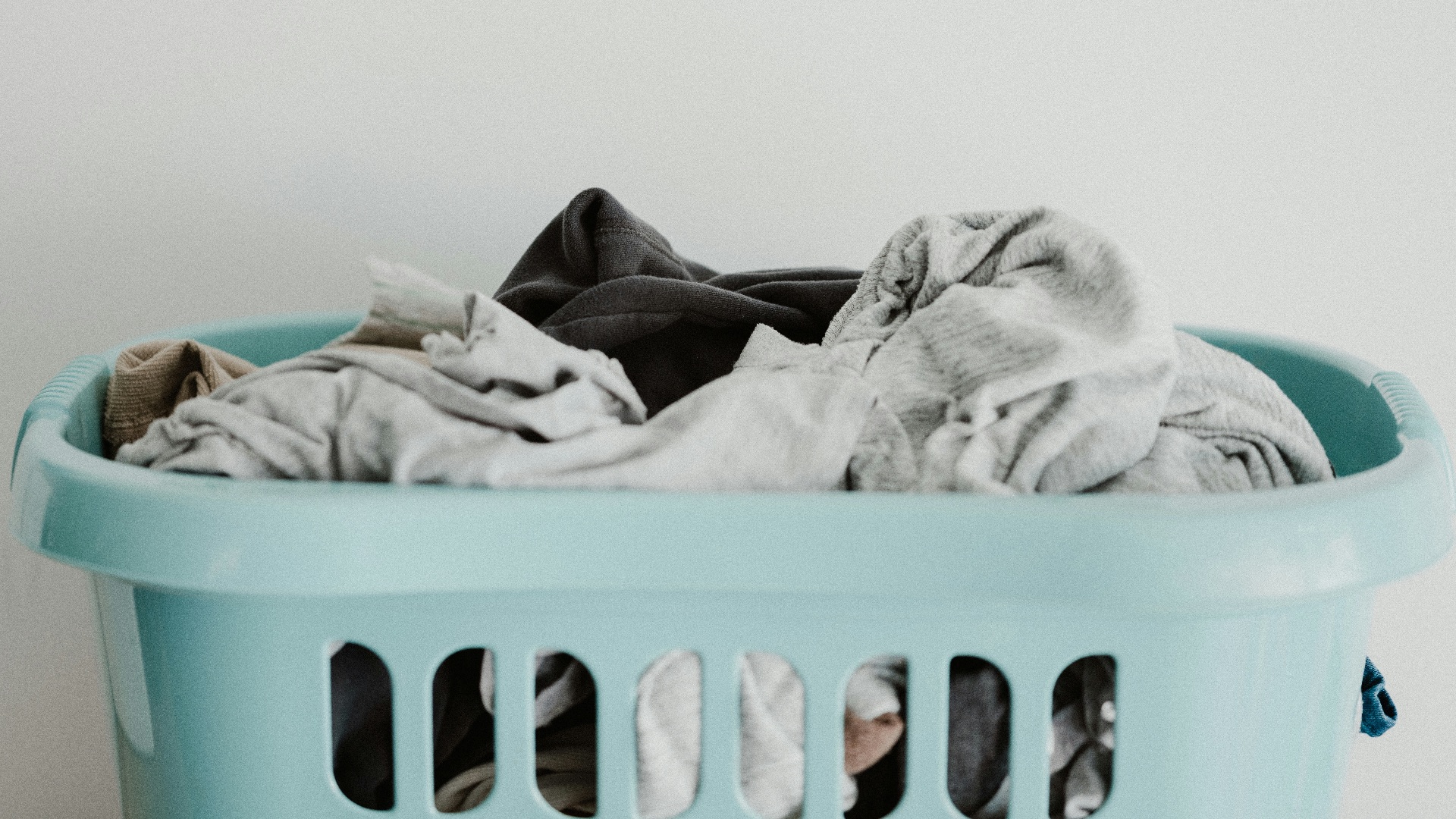 white textile on blue plastic laundry basket