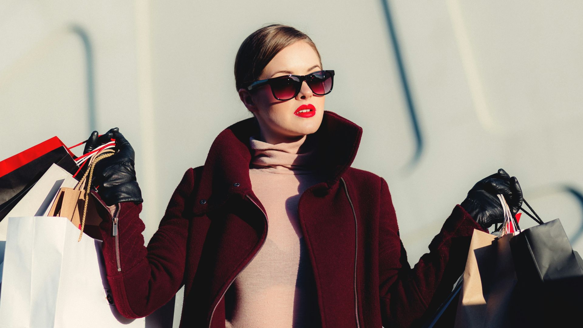 photo of woman holding white and black paper bags