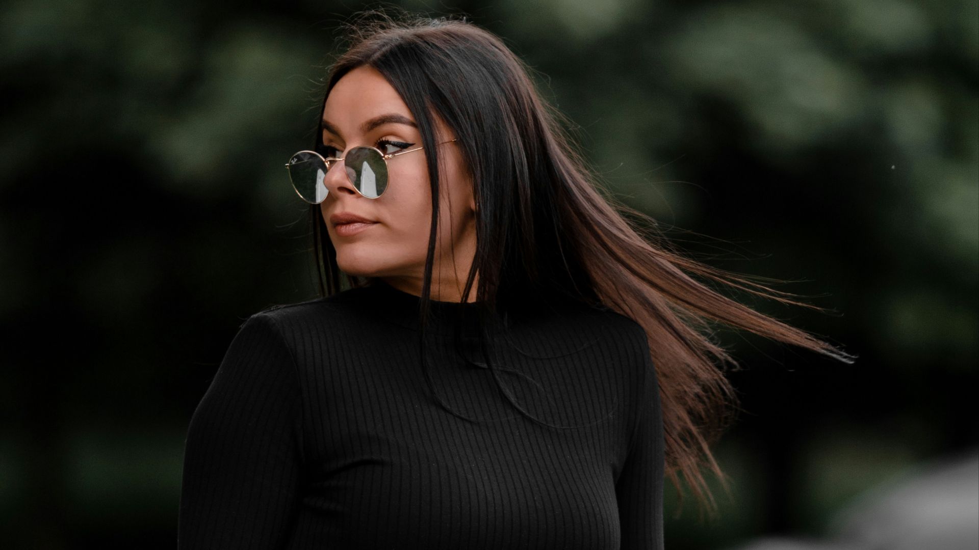 woman in black long sleeve shirt sitting on white wooden bench during daytime