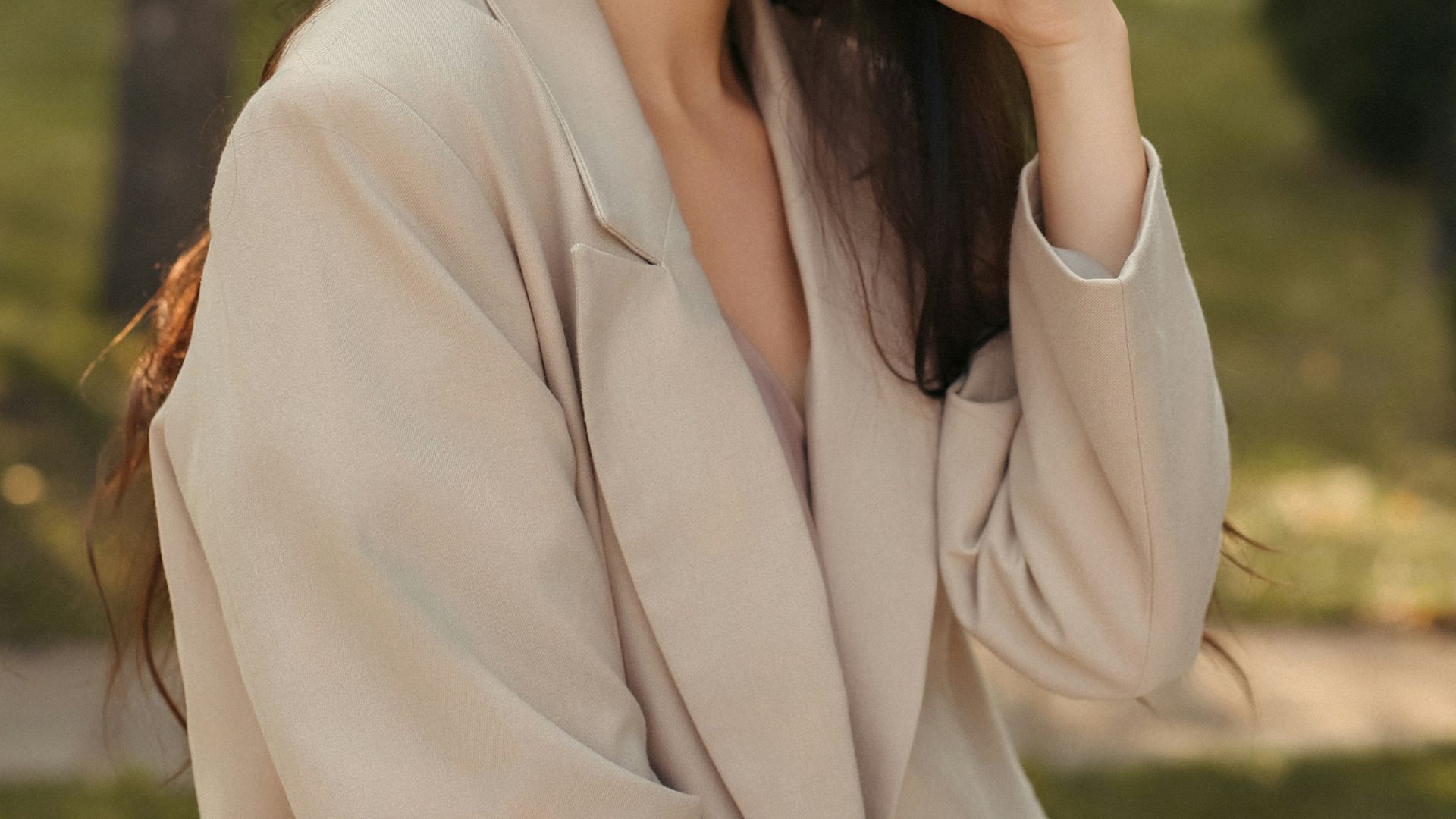 a woman in a beige suit posing for a picture