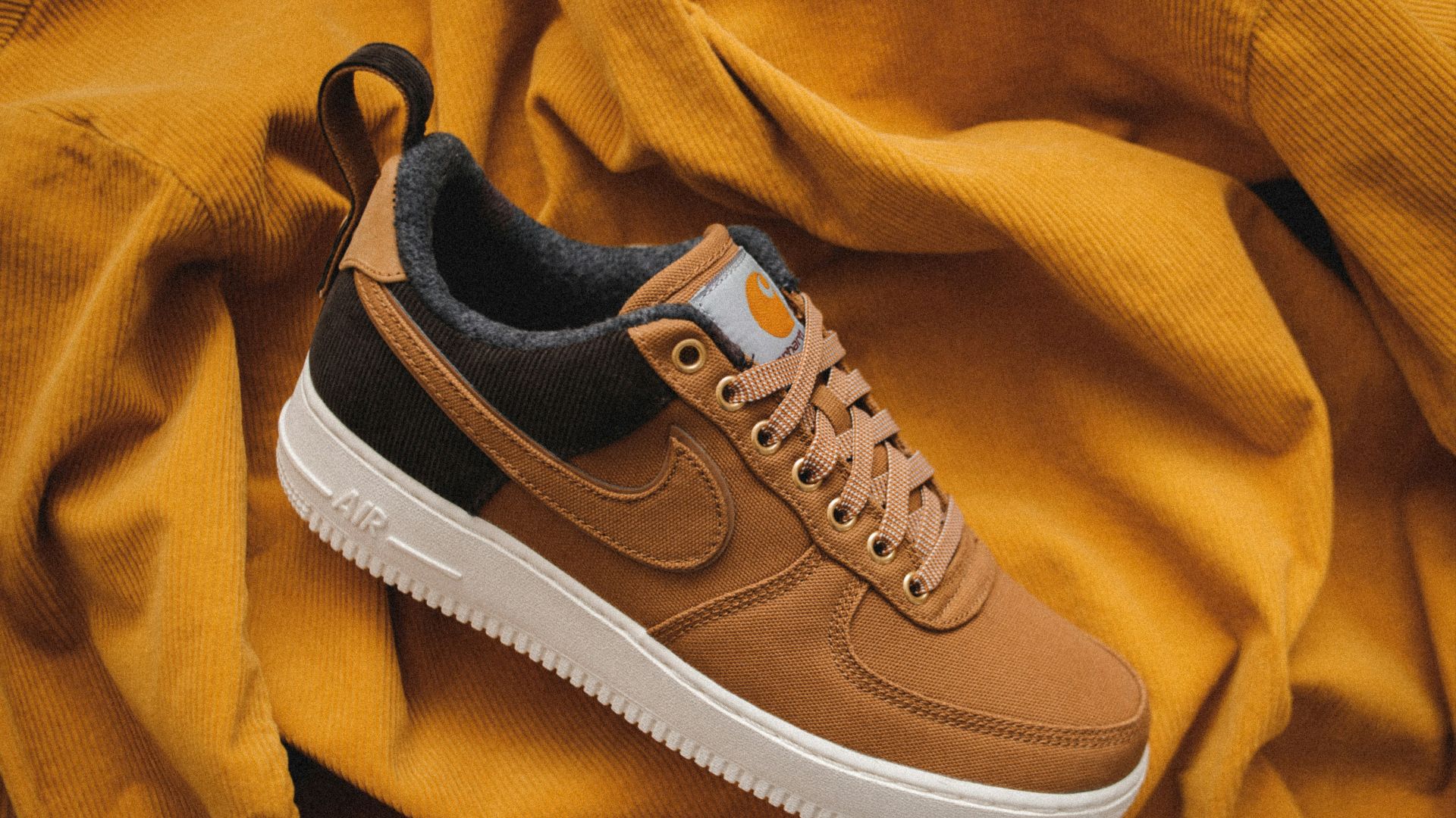 brown Nike sneaker on yellow textile