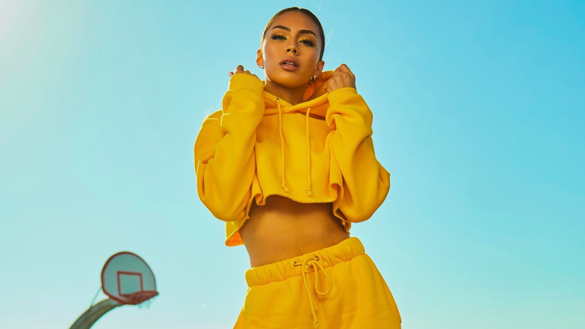 woman in yellow tracksuit standing on basketball court side