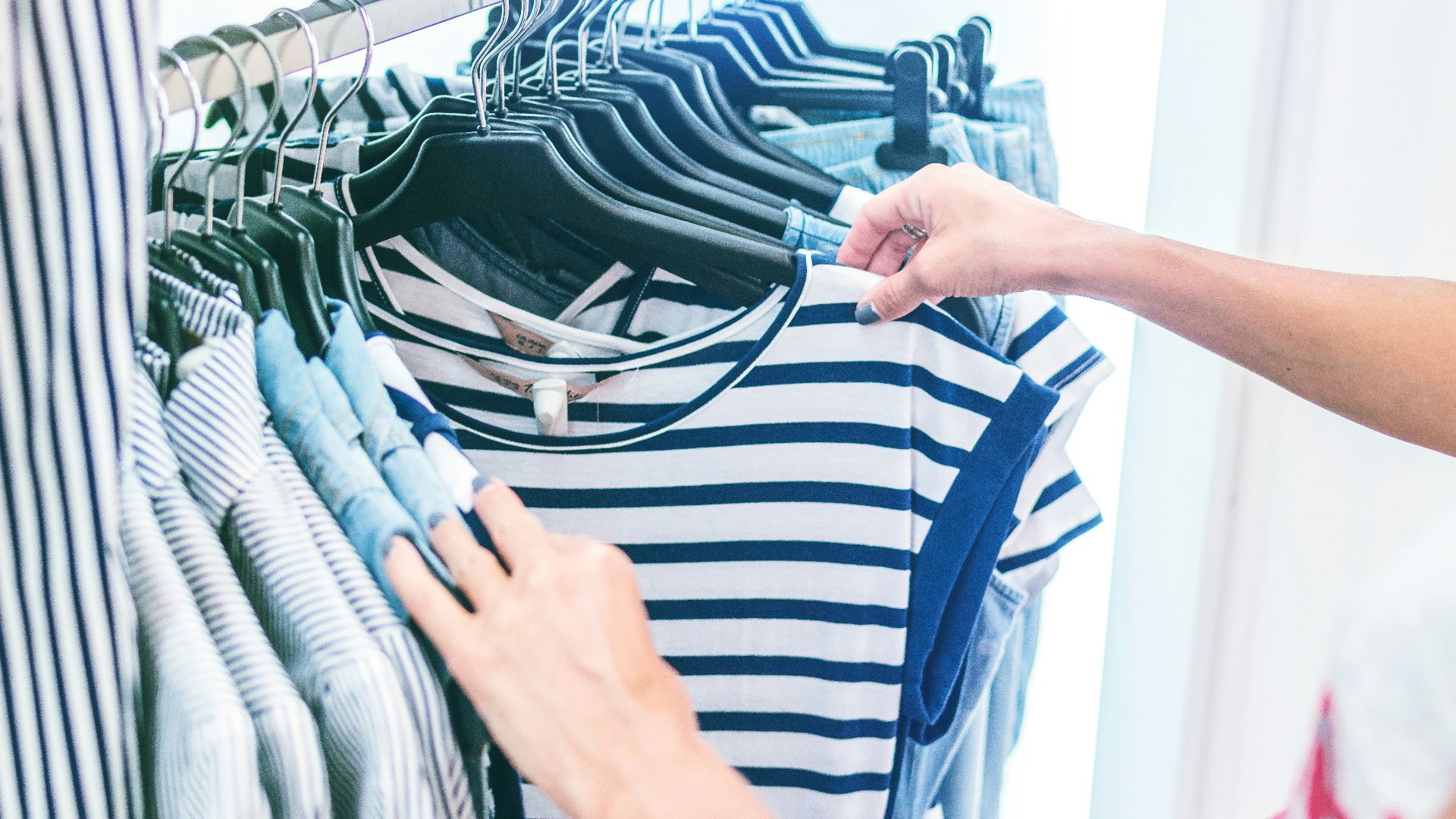 person holding white and black striped shirt