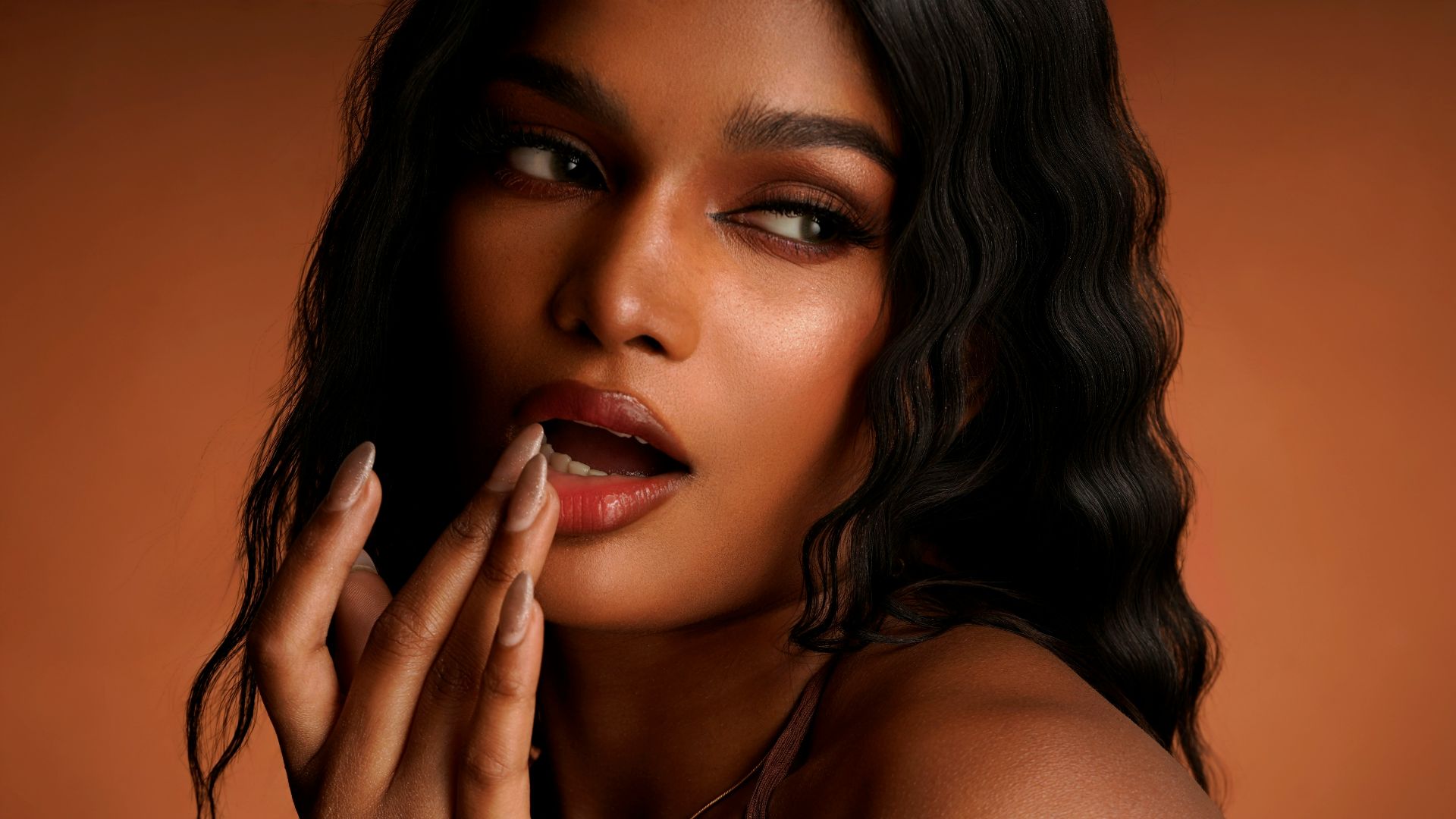 A woman poses, showing her makeup.