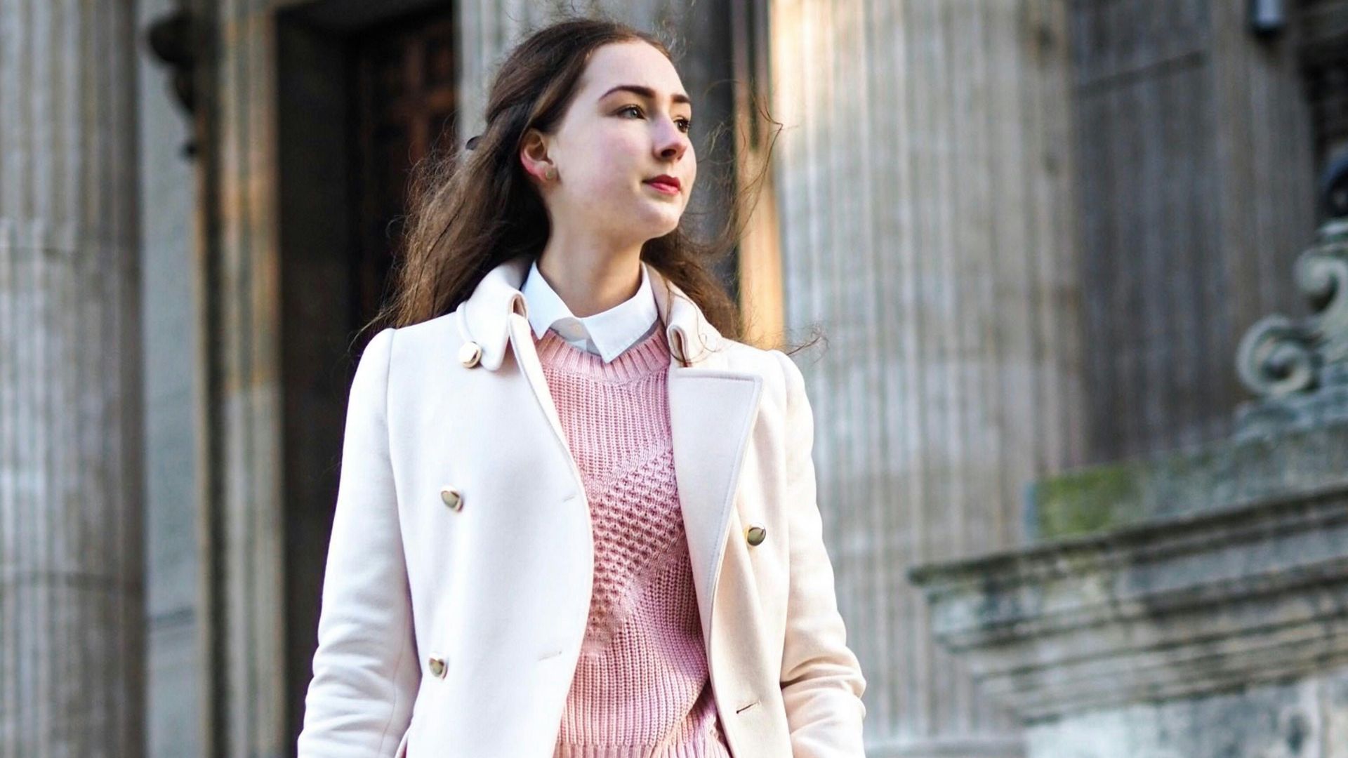 woman wearing white coat carrying crossbody bag