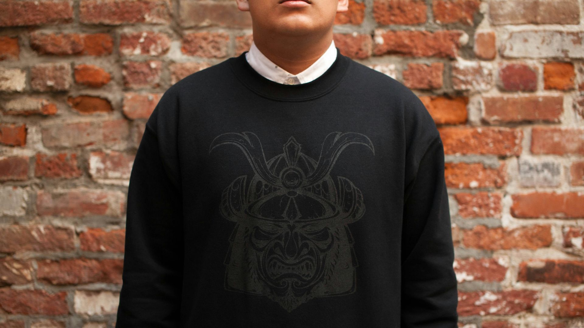 man standing near brown bricked wall