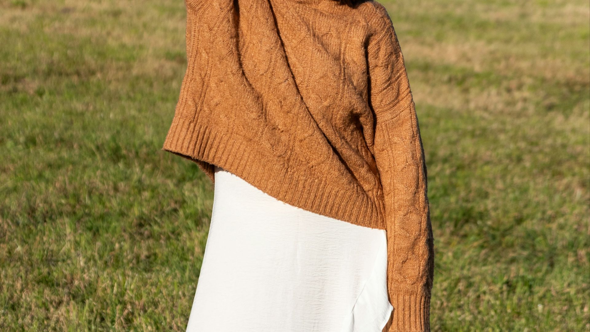 Young woman in a brown sweater and white skirt