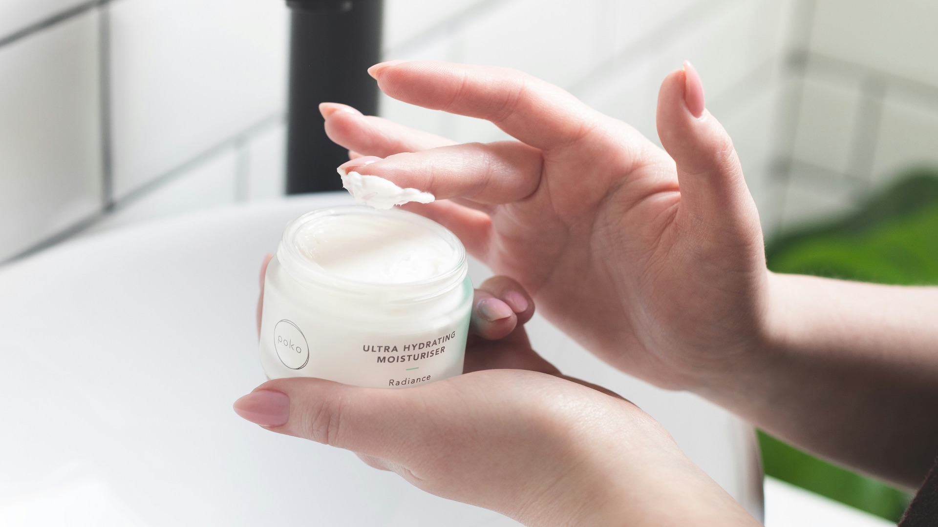 person holding white and black plastic bottle