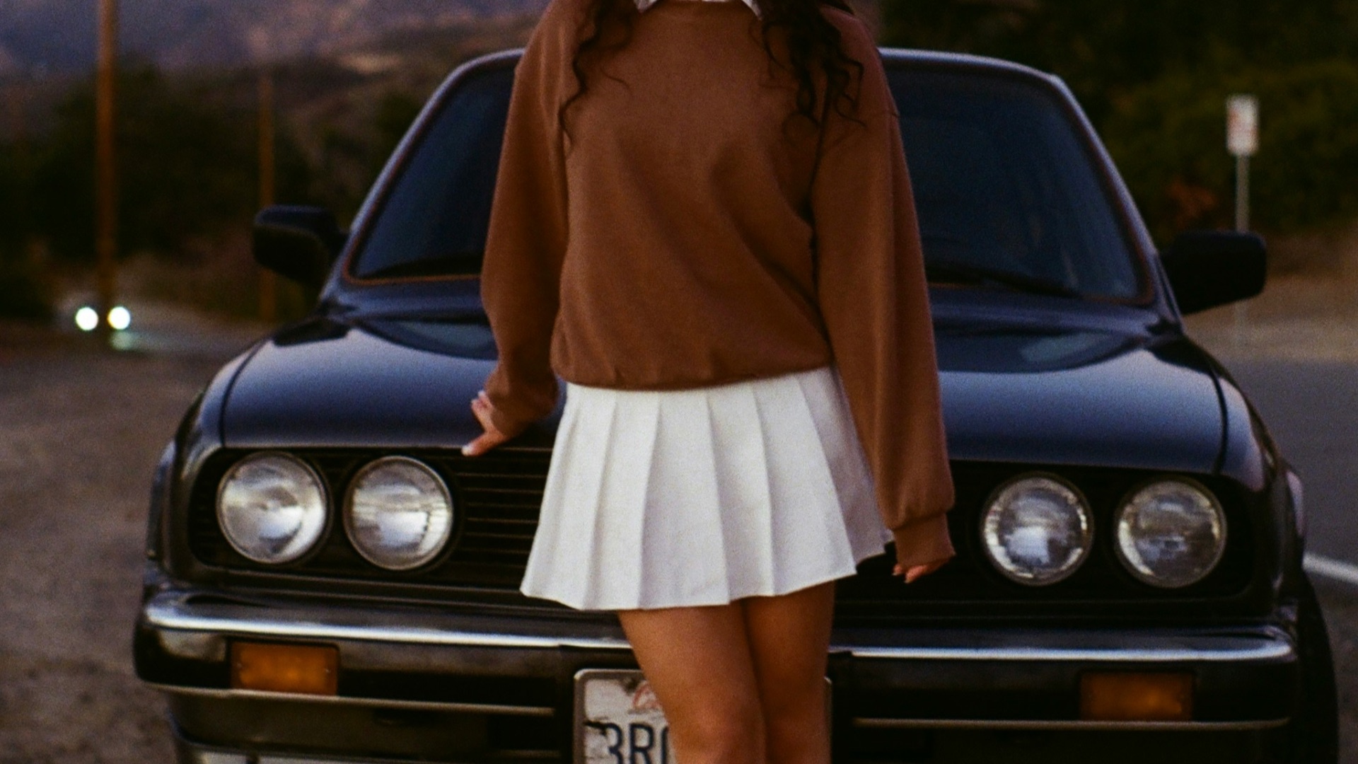woman in brown long sleeve dress standing beside black car during daytime