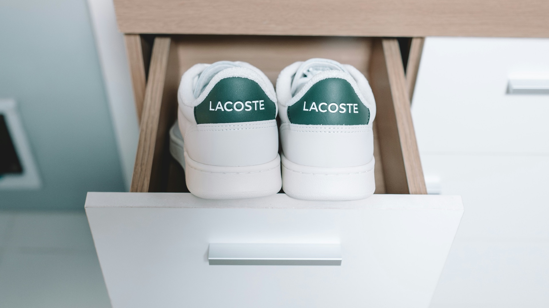A pair of white shoes sitting on top of a drawer