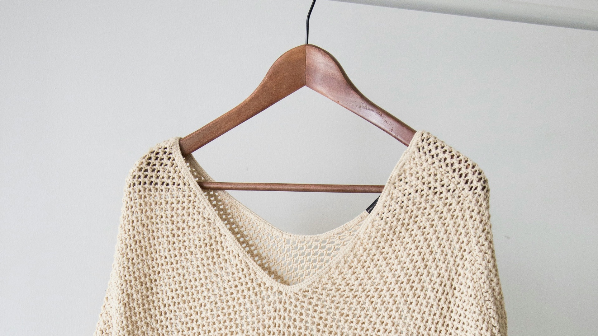 white v neck shirt on brown clothes hanger