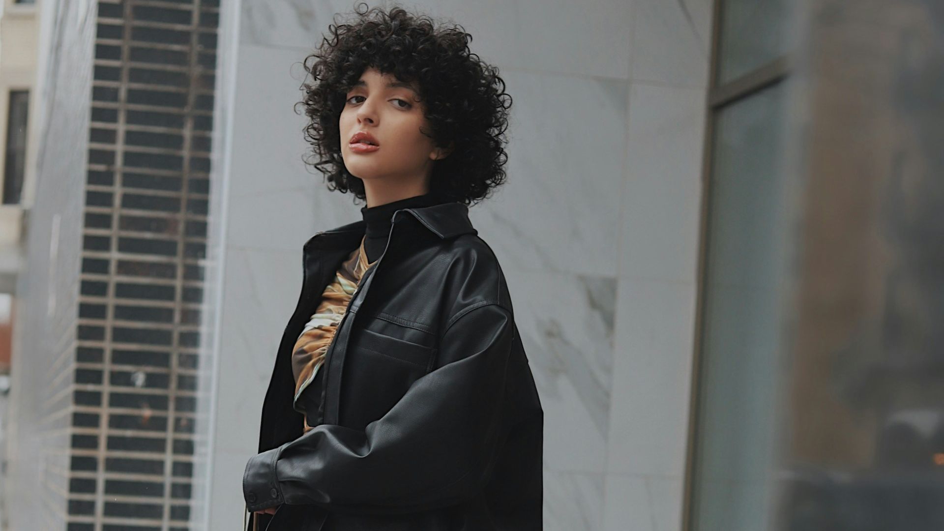 woman in black coat standing on white floor