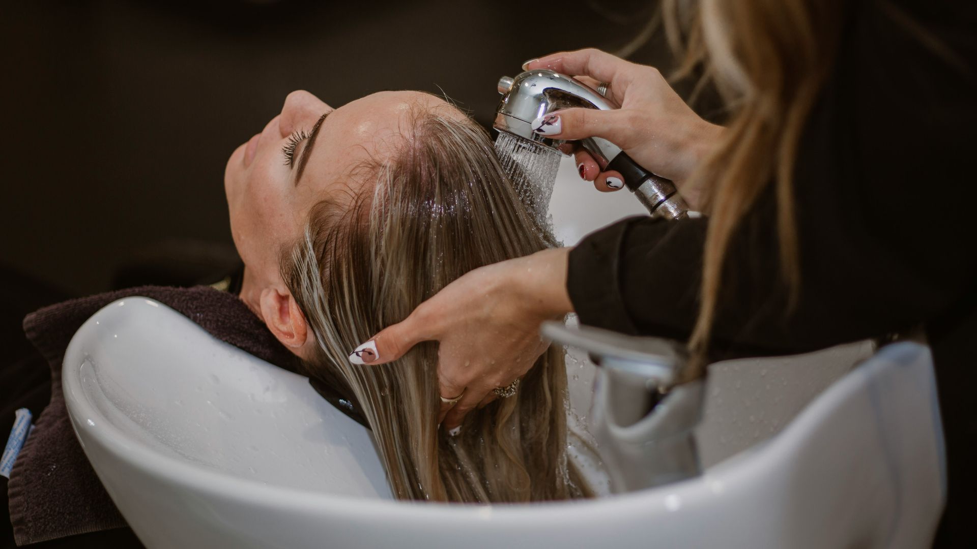 a woman getting her hair cut by a hair stylist
