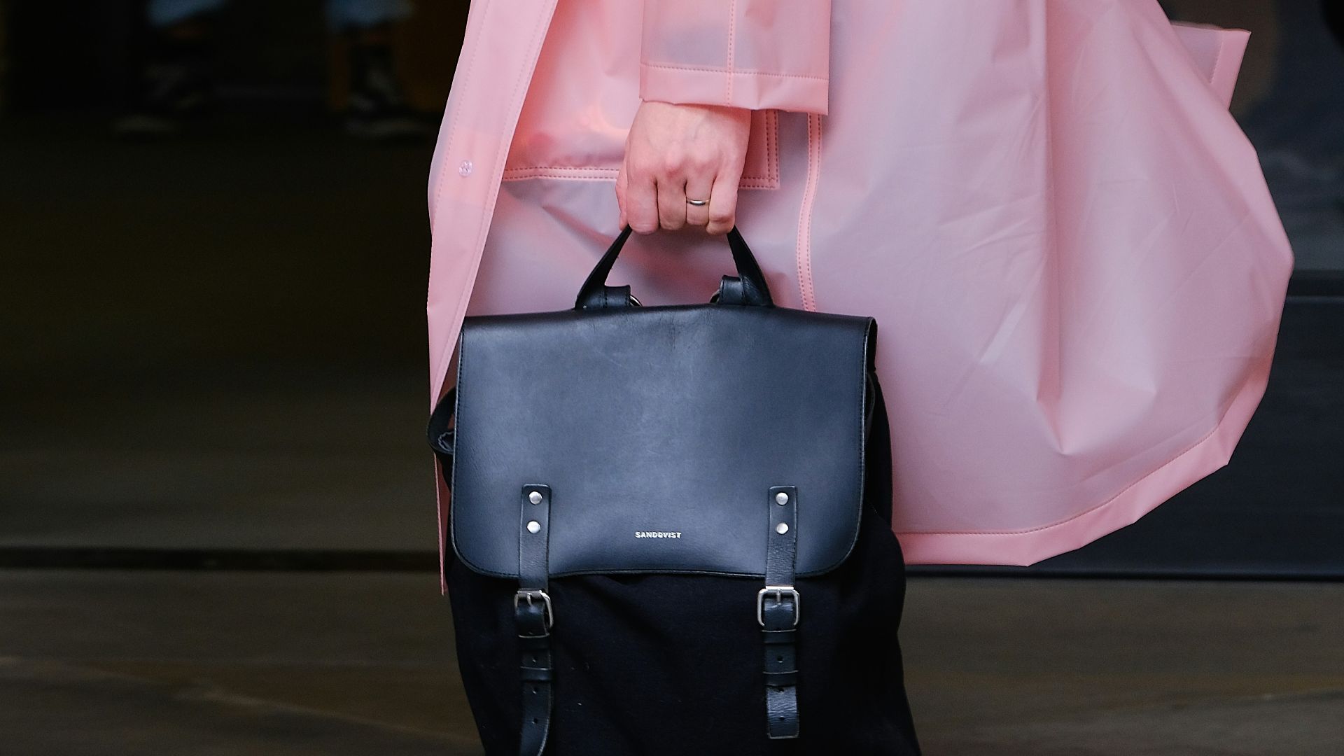 person in pink coat holding leather bag