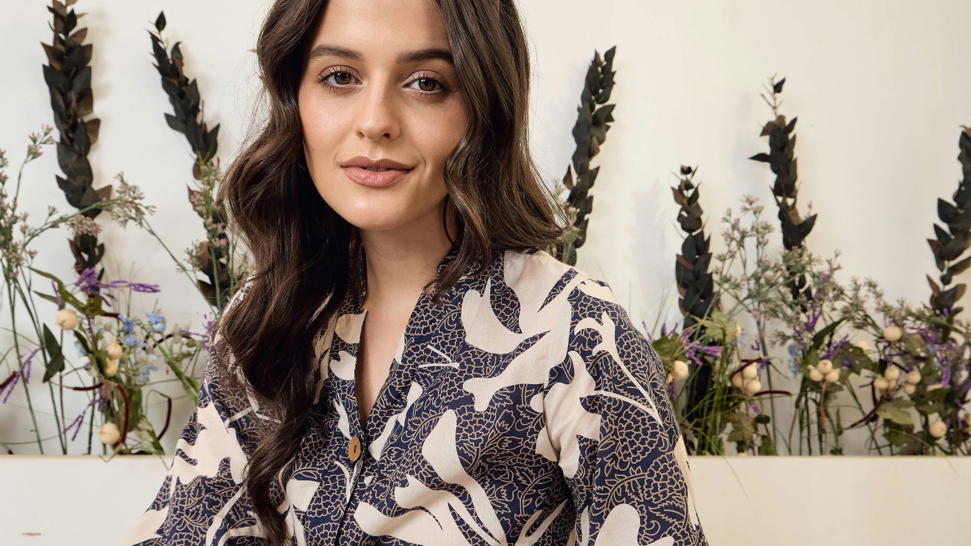 Woman in floral patterned pajamas sitting on floor