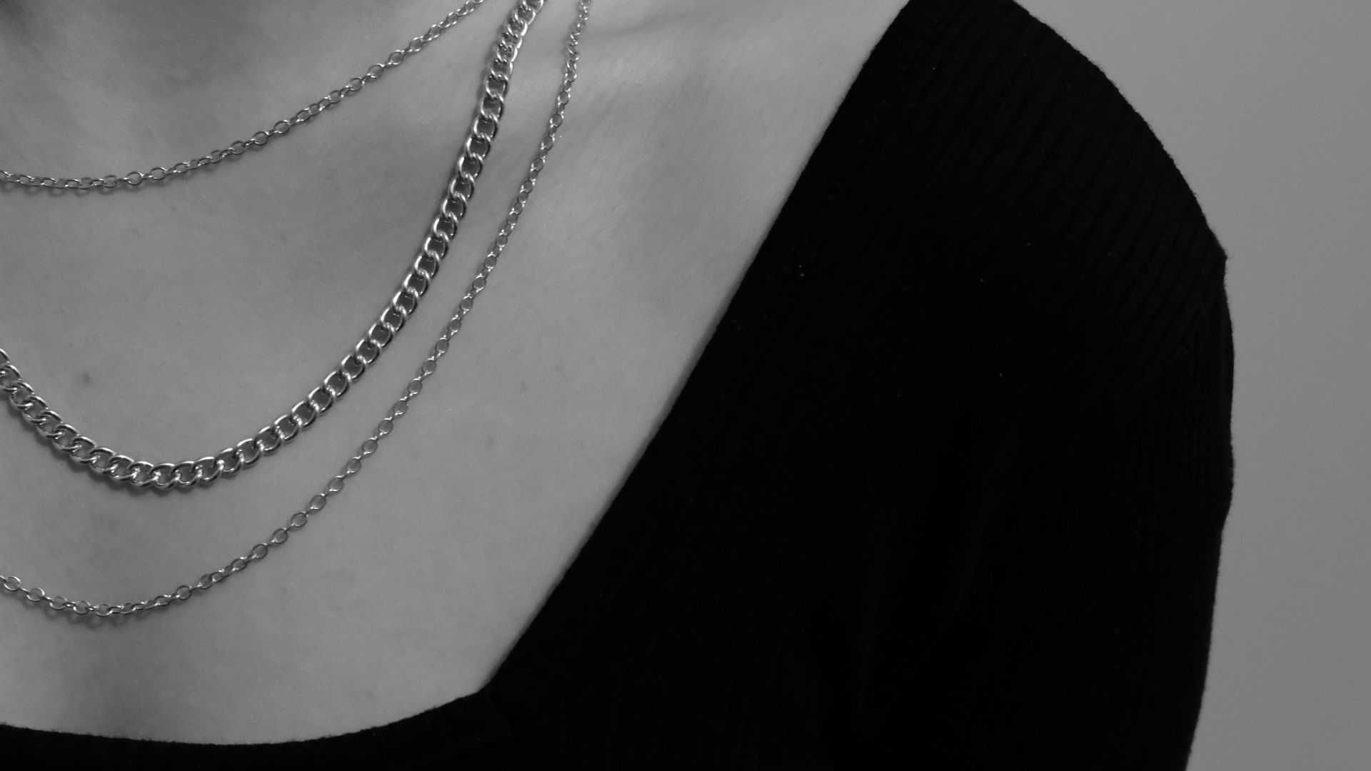 a woman wearing a black shirt and a silver chain necklace