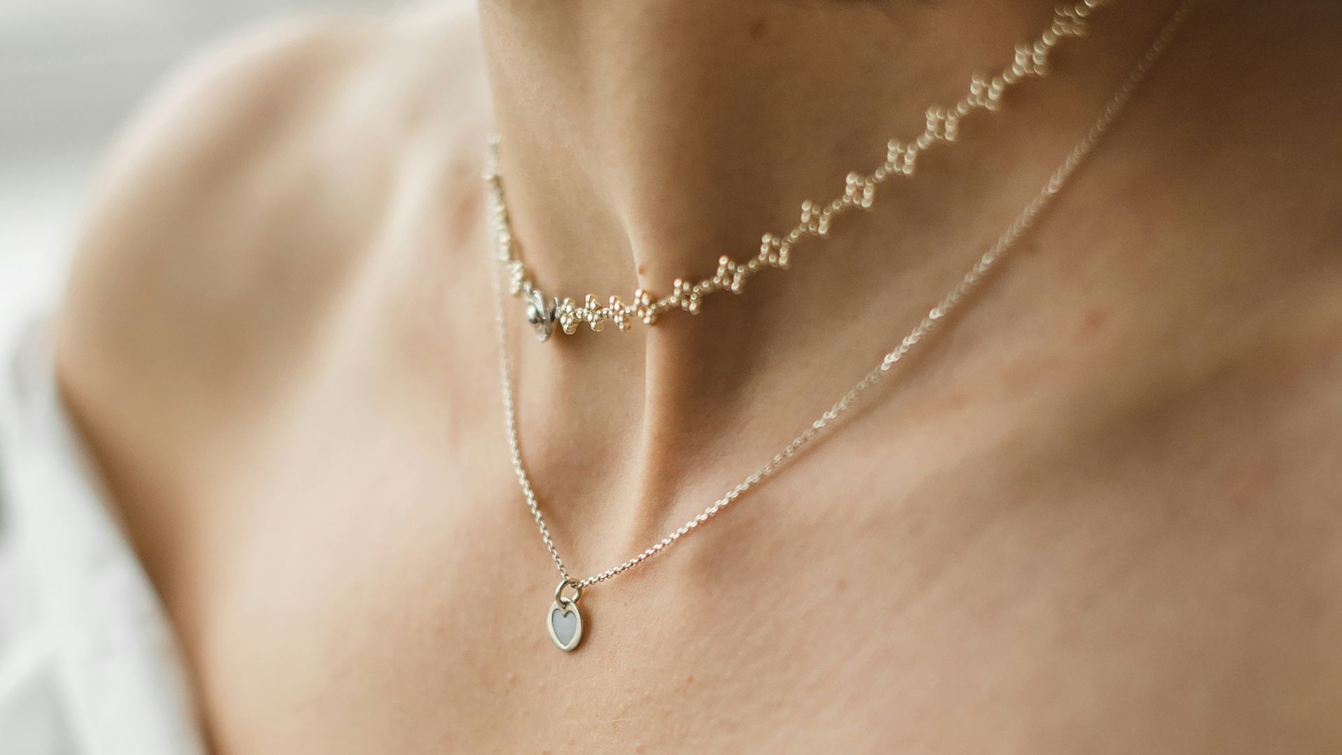 woman in white off shoulder shirt wearing silver necklace