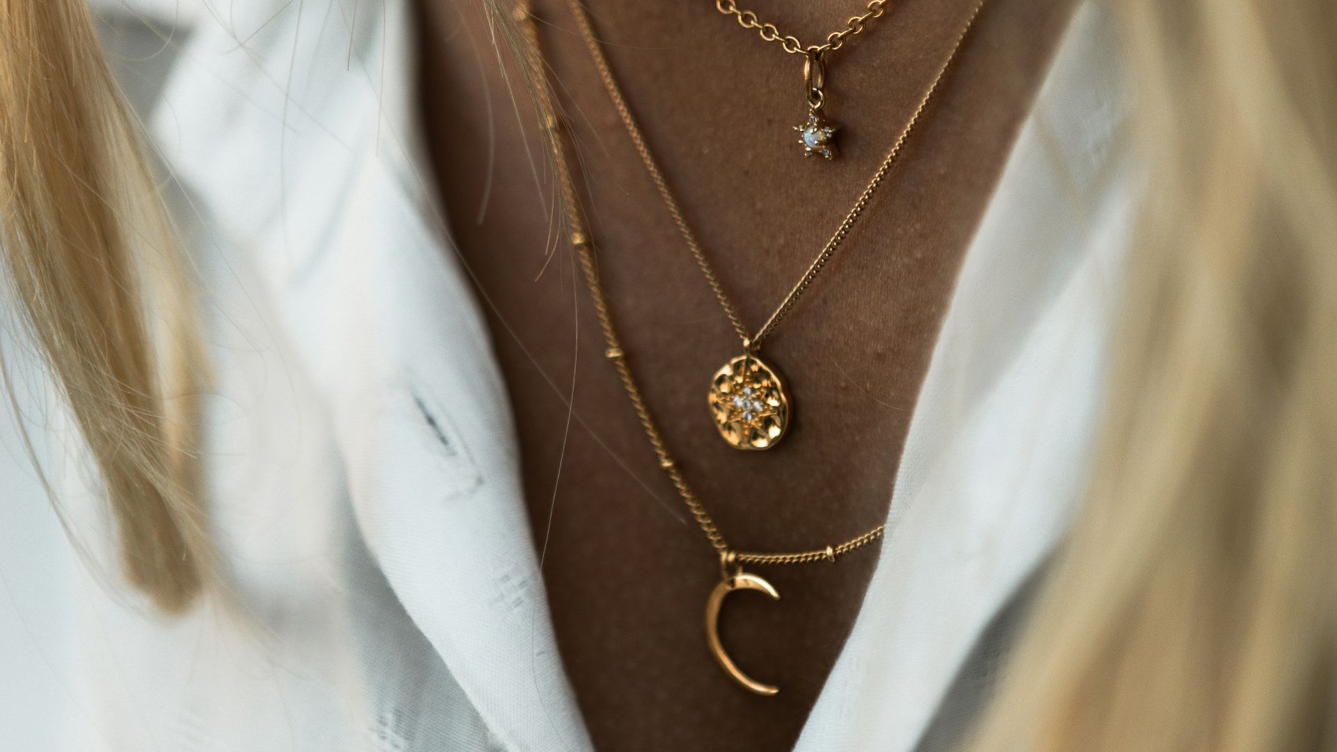 woman wearing gold necklace and white shirt