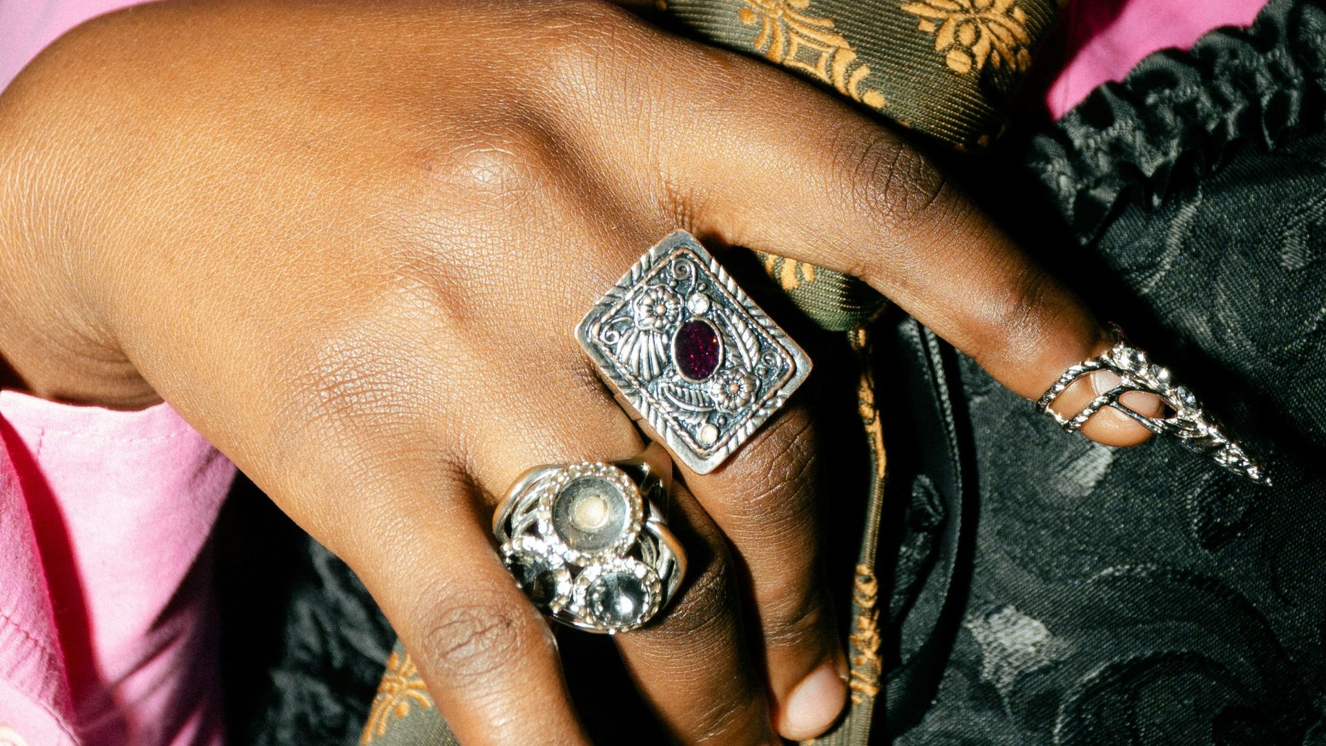 Person wearing a pink shirt, corset, and patterned tie.