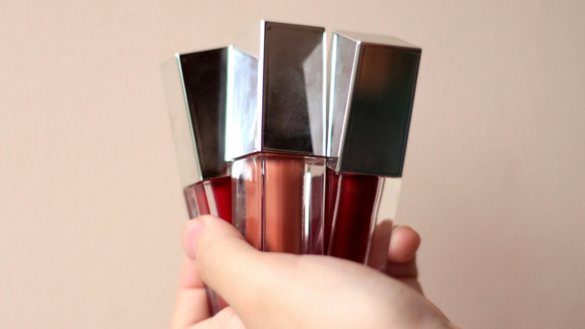 person holding silver and red tube