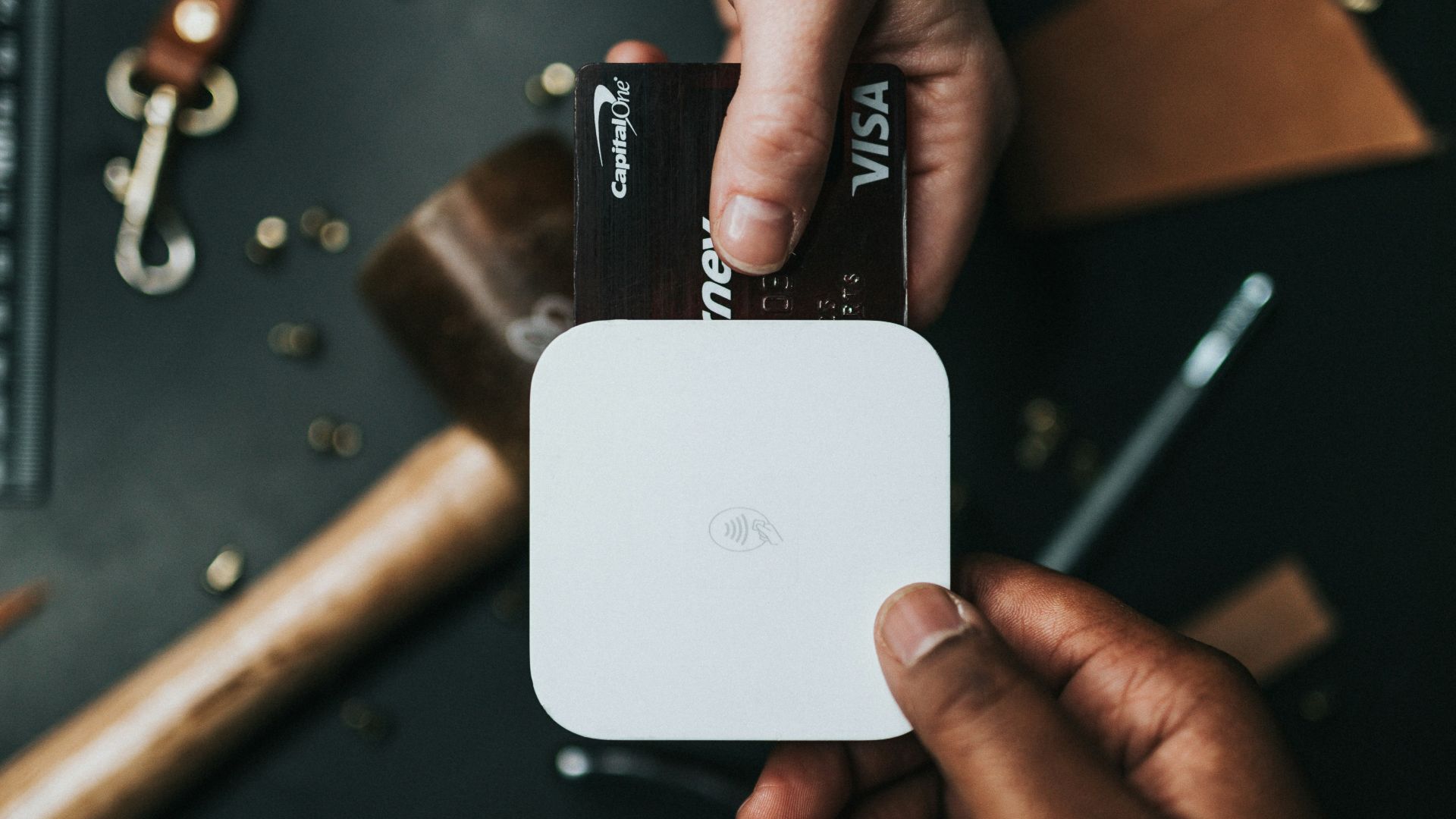 person holding Visa card and white device