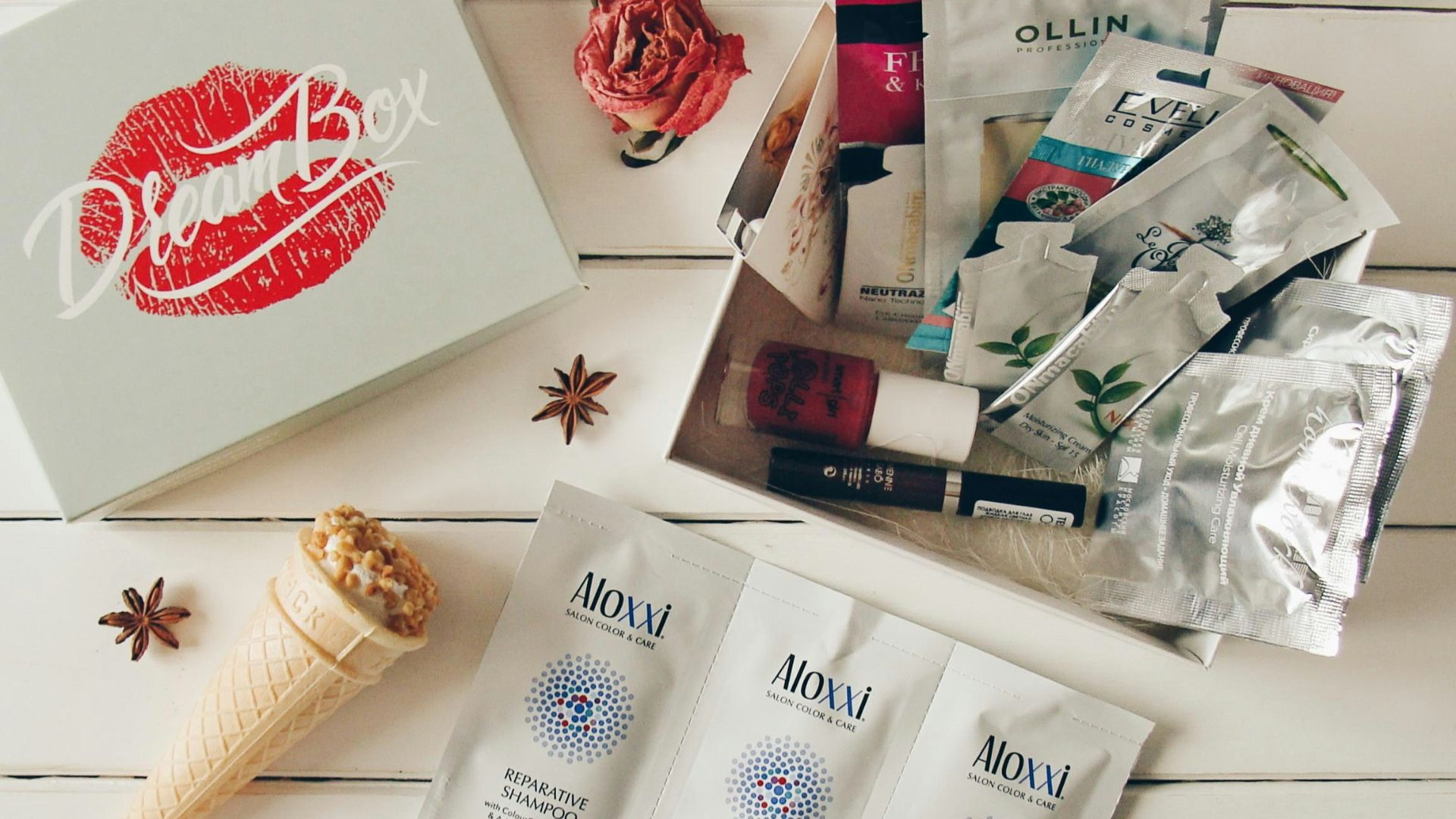 Beauty products and a box on a white wooden surface.