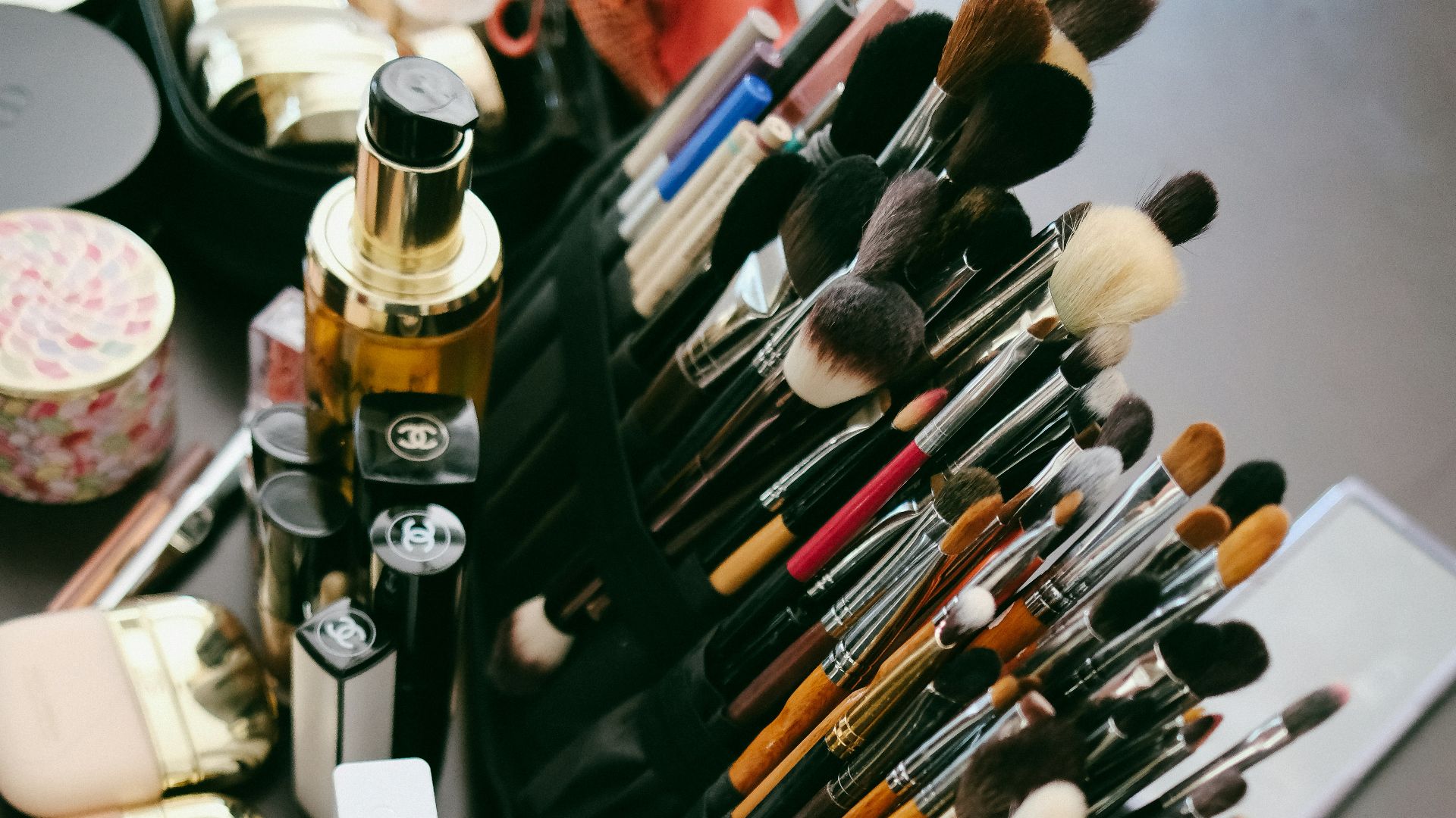 Collection of makeup brushes and cosmetics arranged neatly.