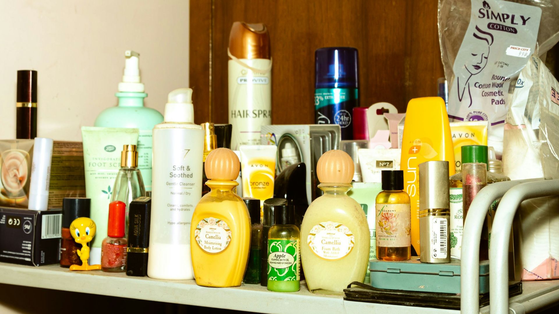 white and yellow plastic bottle on brown wooden shelf