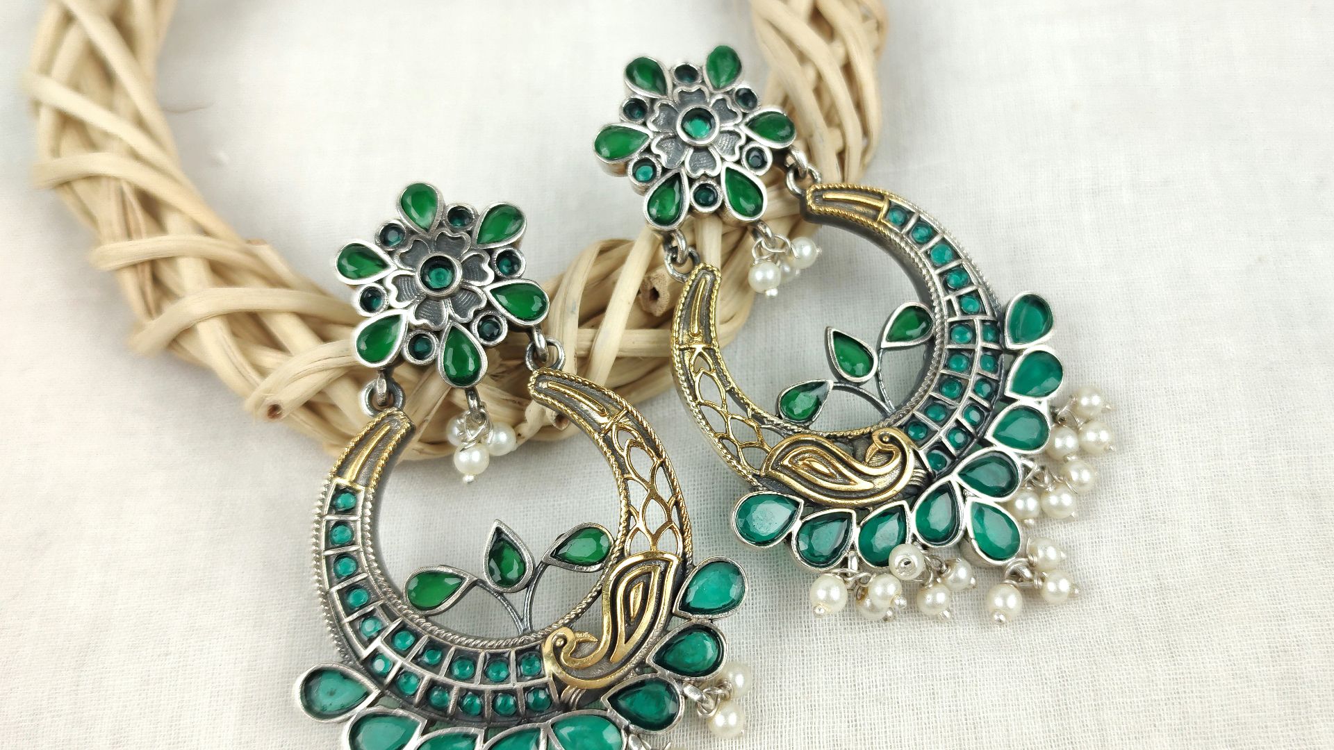 a close up of a pair of green and white earrings