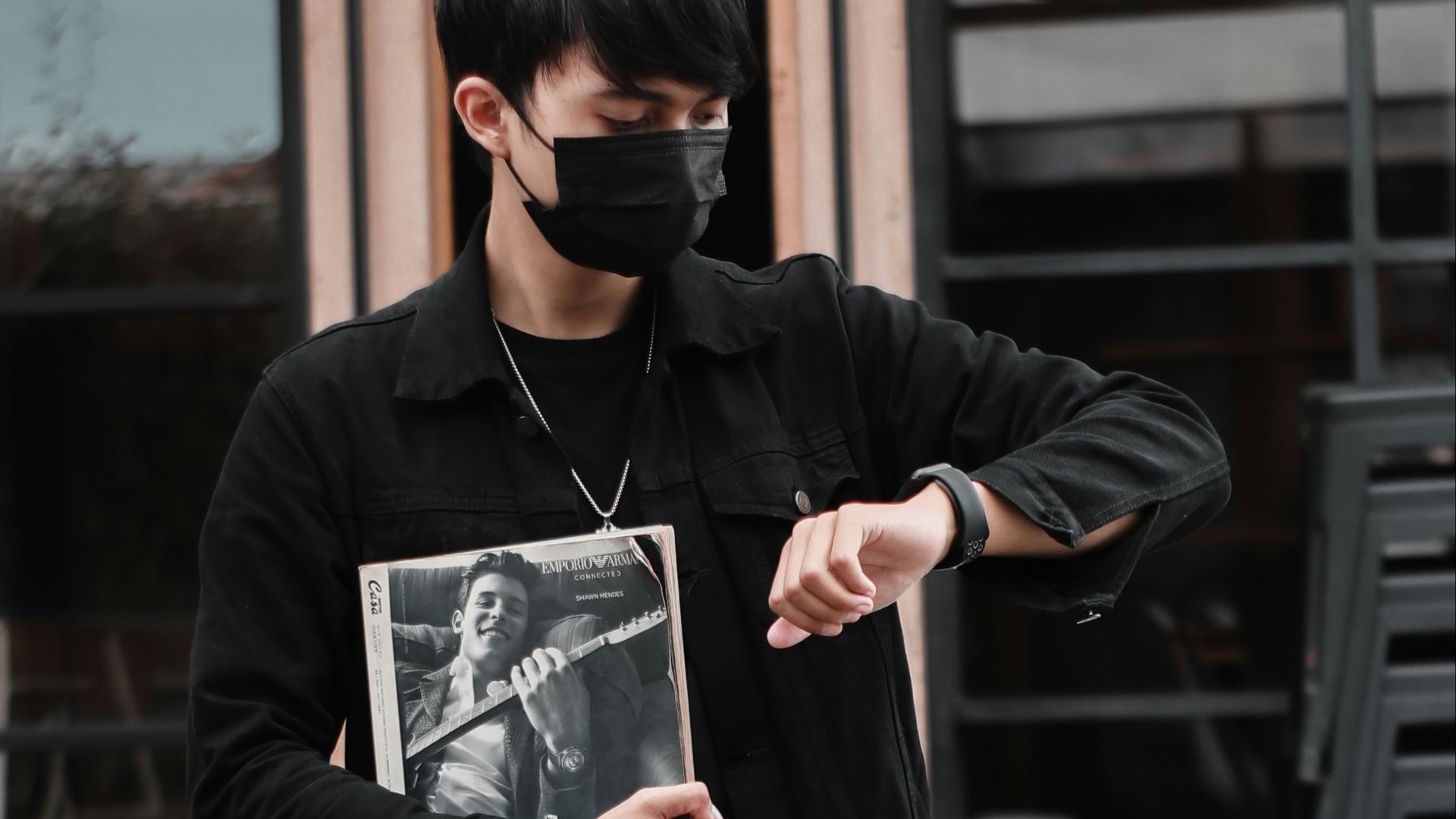 man in black dress shirt and black pants holding black smartphone