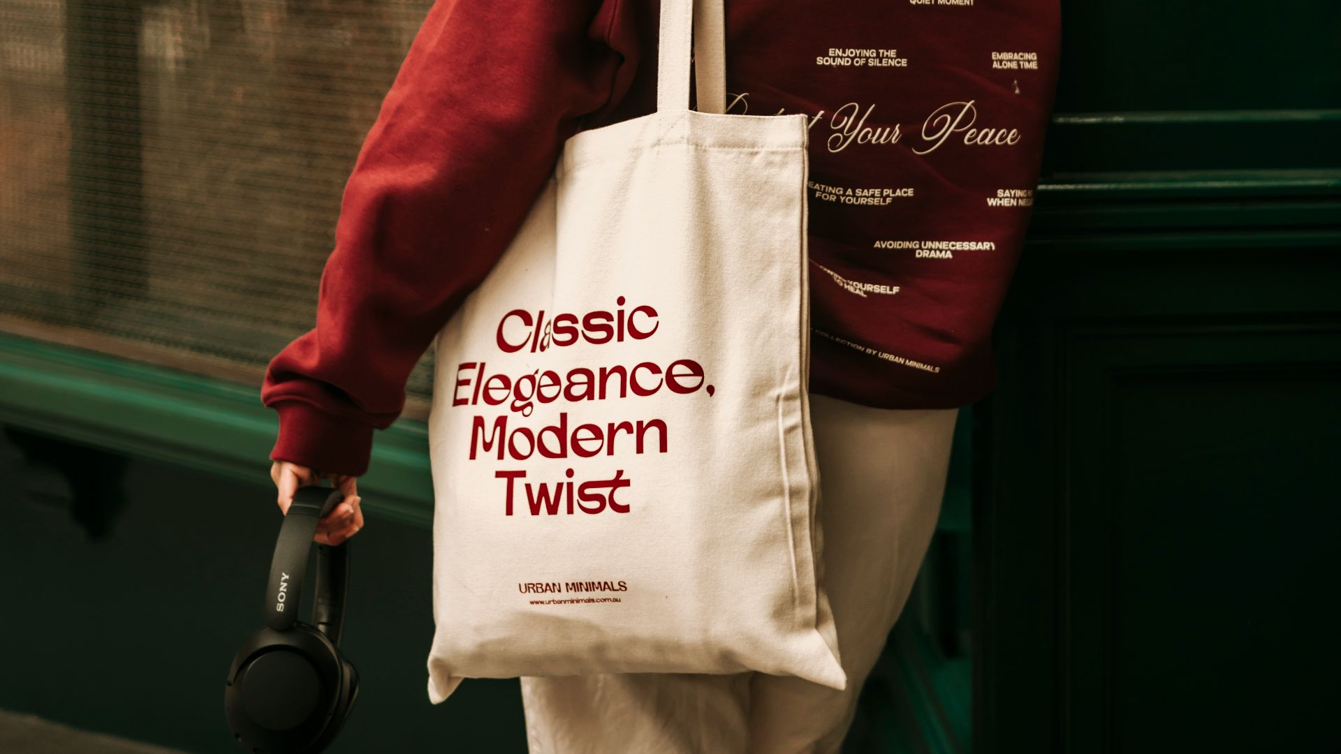 A woman walking down a street carrying a bag