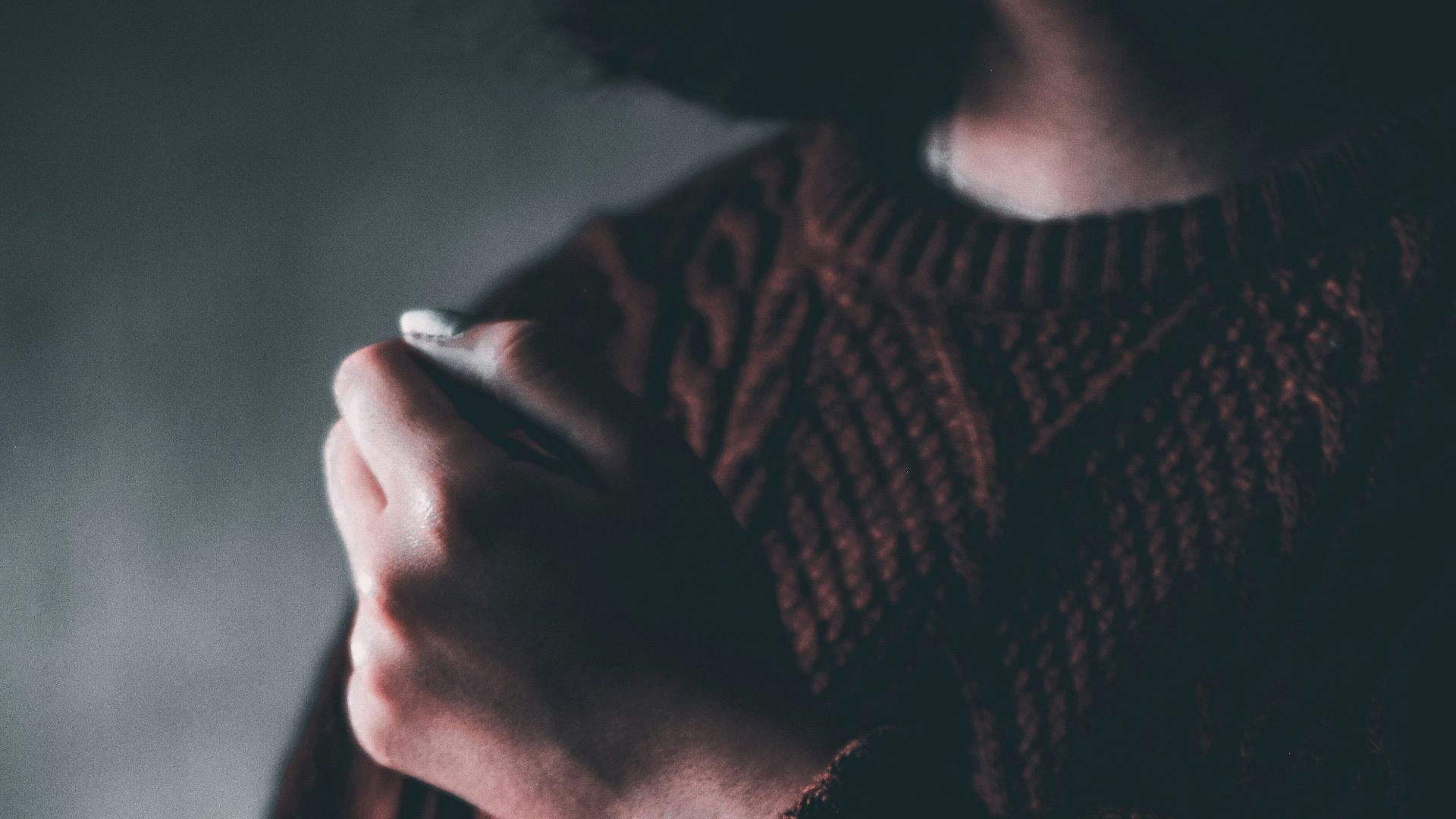 person wearing brown knit sweater