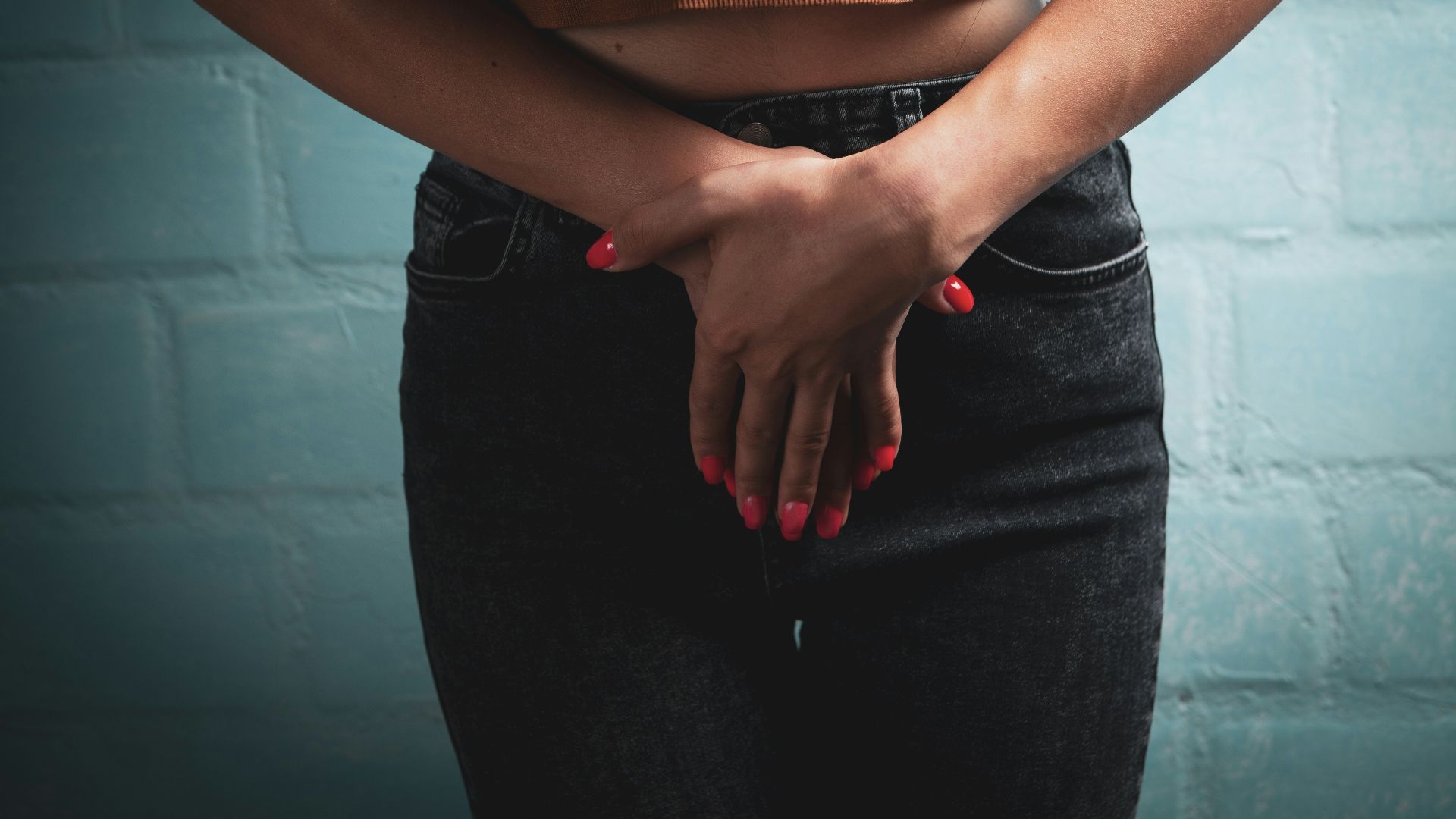 Woman in jeans and crop top covering herself